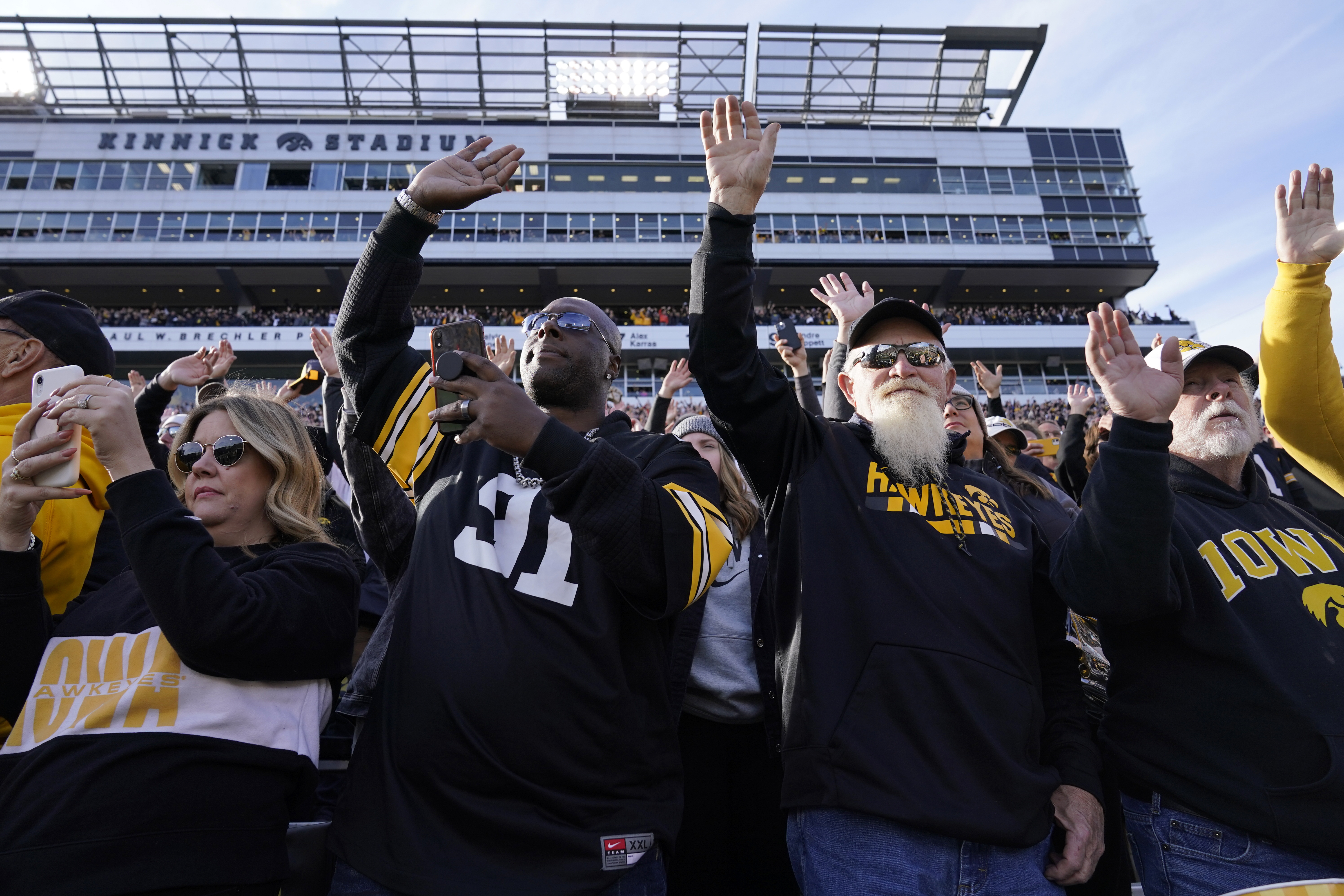FILE - Iowa fans wave to children in the University of Iowa Stead Family Children's Hospital at the end of the first quarter of an NCAA college football game between Iowa and Illinois, Nov. 20, 2021, in Iowa City, Iowa. (Charlie Neibergall - AP)