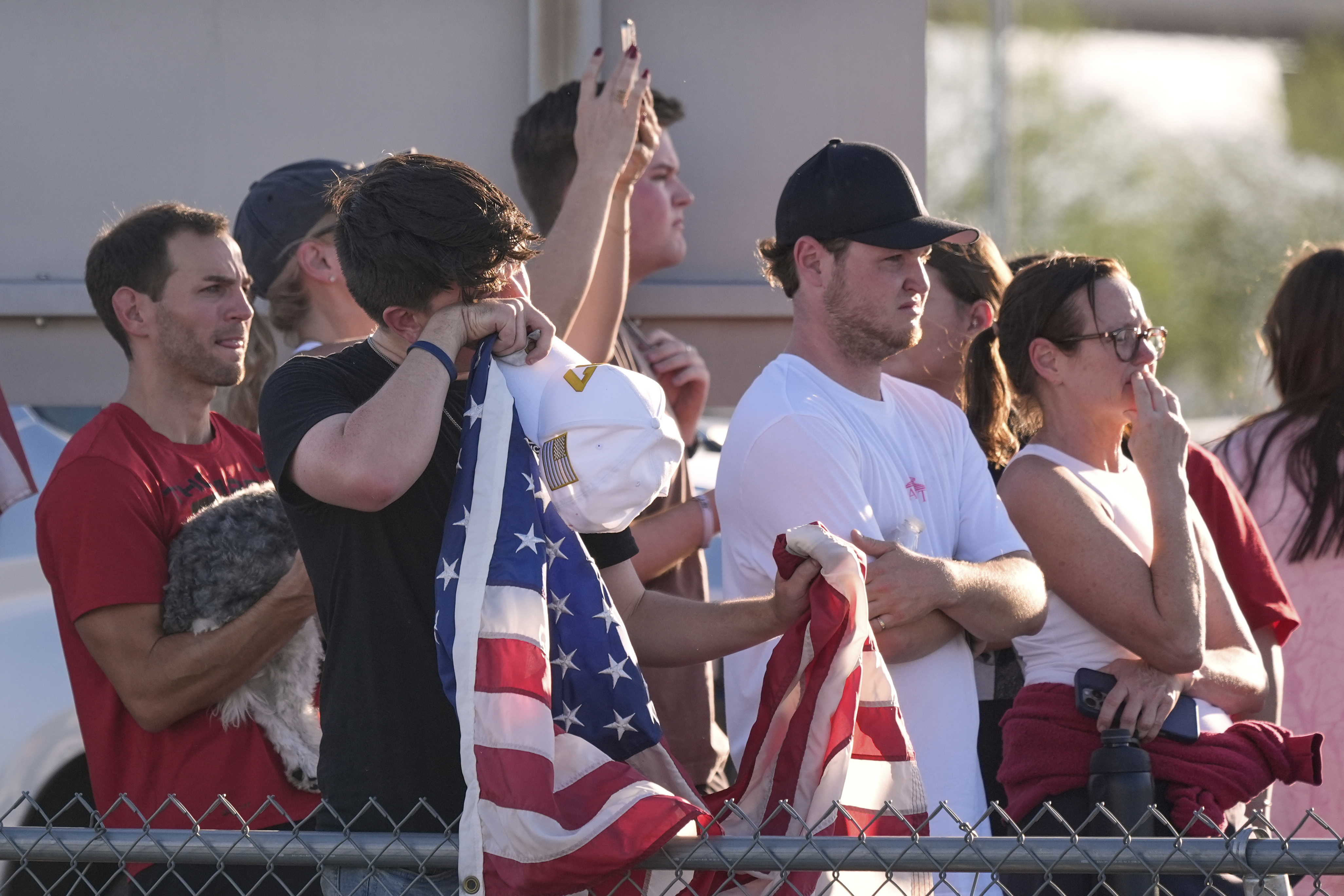People watch a hearse containing the body of Charlie Kirk, the CEO and co-founder of Turning Point USA, who was shot and killed on Wednesday leave after the body arrived aboard Air Force Two at Phoenix Sky Harbor International Airport, Thursday, Sept. 11, 2025, in Phoenix. (Ross D. Franklin - AP)