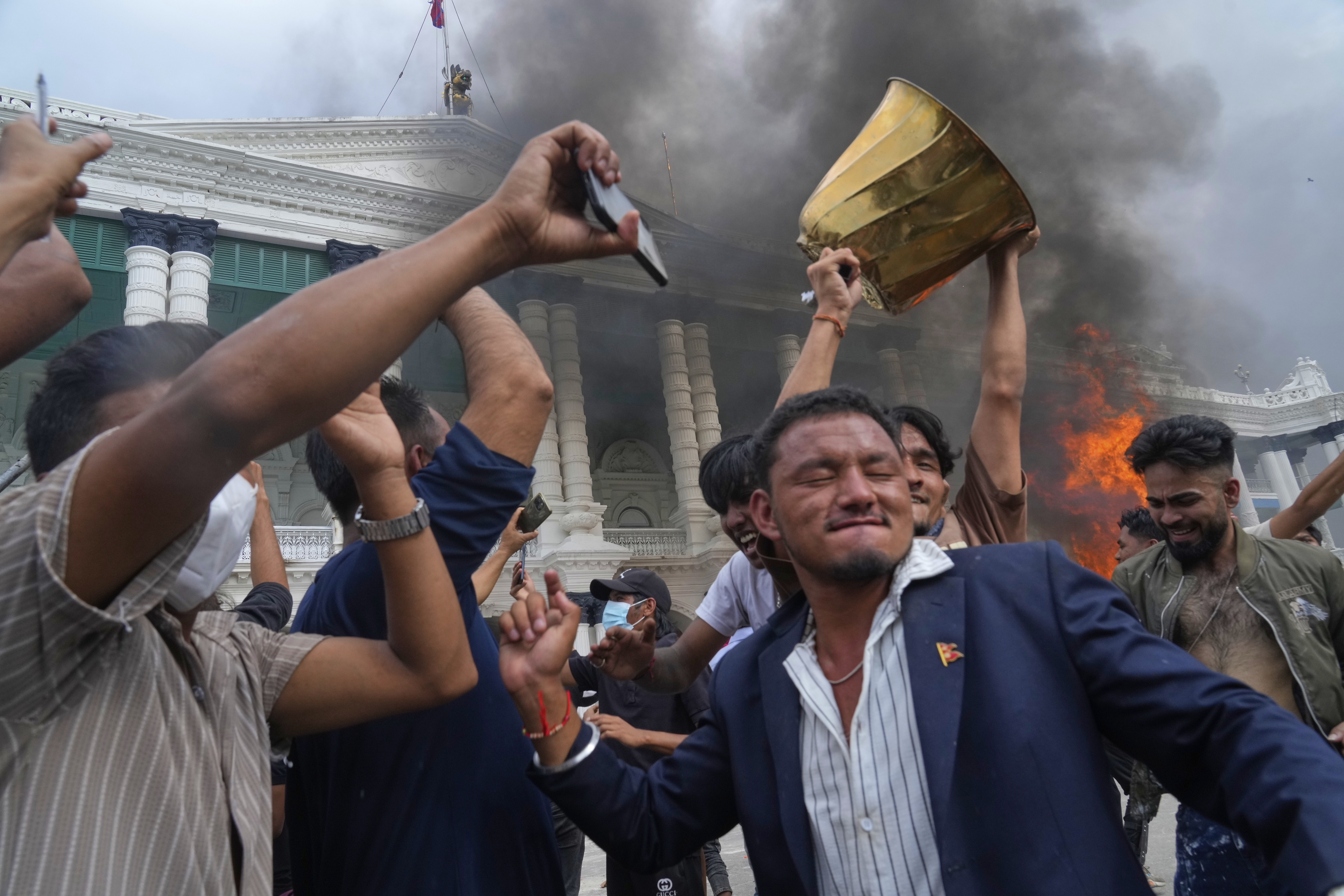 Protesters celebrate at the Singha Durbar, the seat of Nepal's government's various ministries and offices after burning it down during a protest against social media ban and corruption in Kathmandu, Nepal, Tuesday, Sept. 9, 2025. (Niranjan Shrestha - AP)