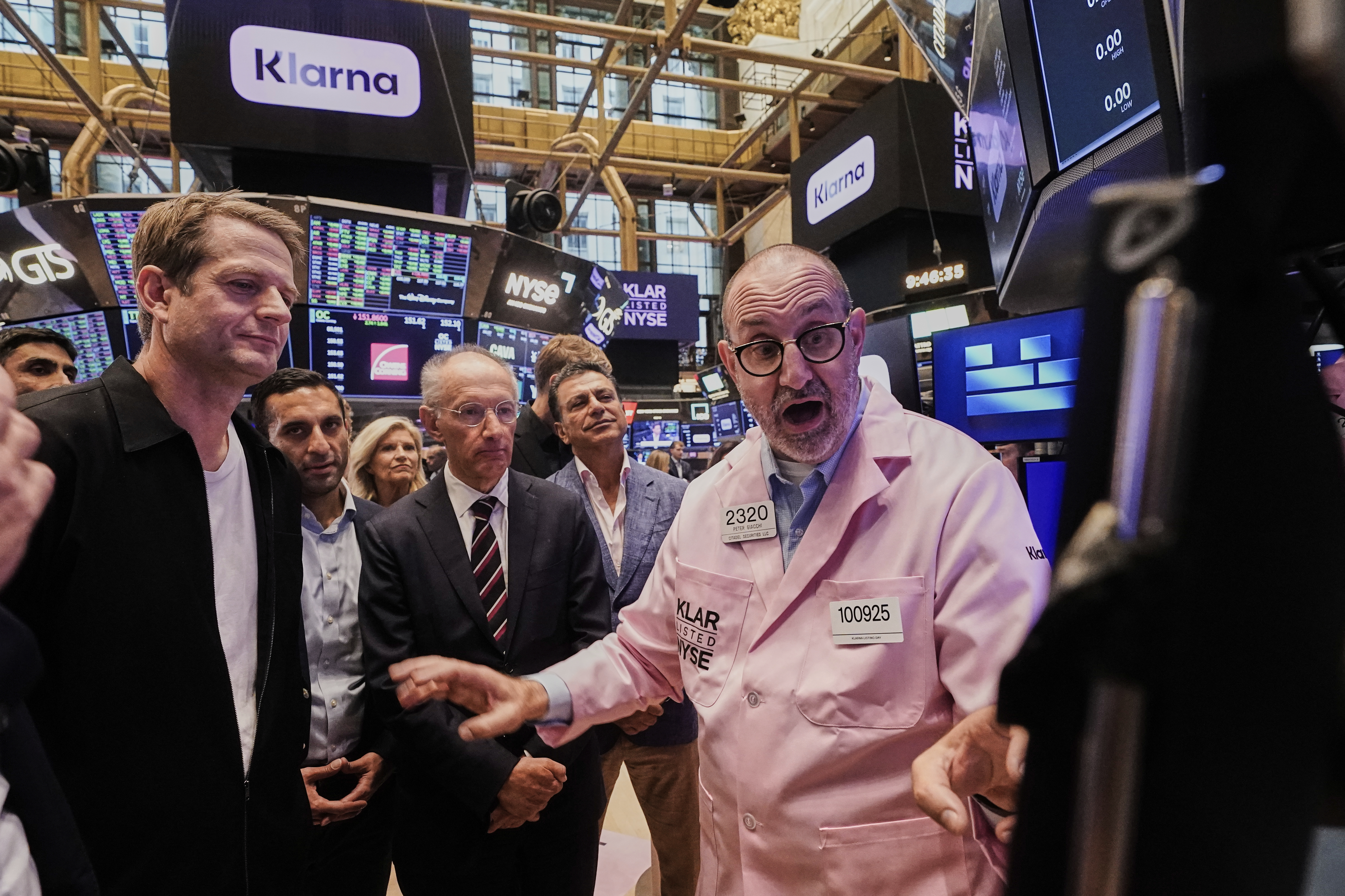 Klarna CEO Sebastian Siemiatkowski, left and company Chairman Michael Moritz, center, meet with specialist Peter Giacchi, right, before their IPO begins trading on the floor of the New York Stock Exchange, Wednesday, Sept. 10, 2025. (Richard Drew - AP)
