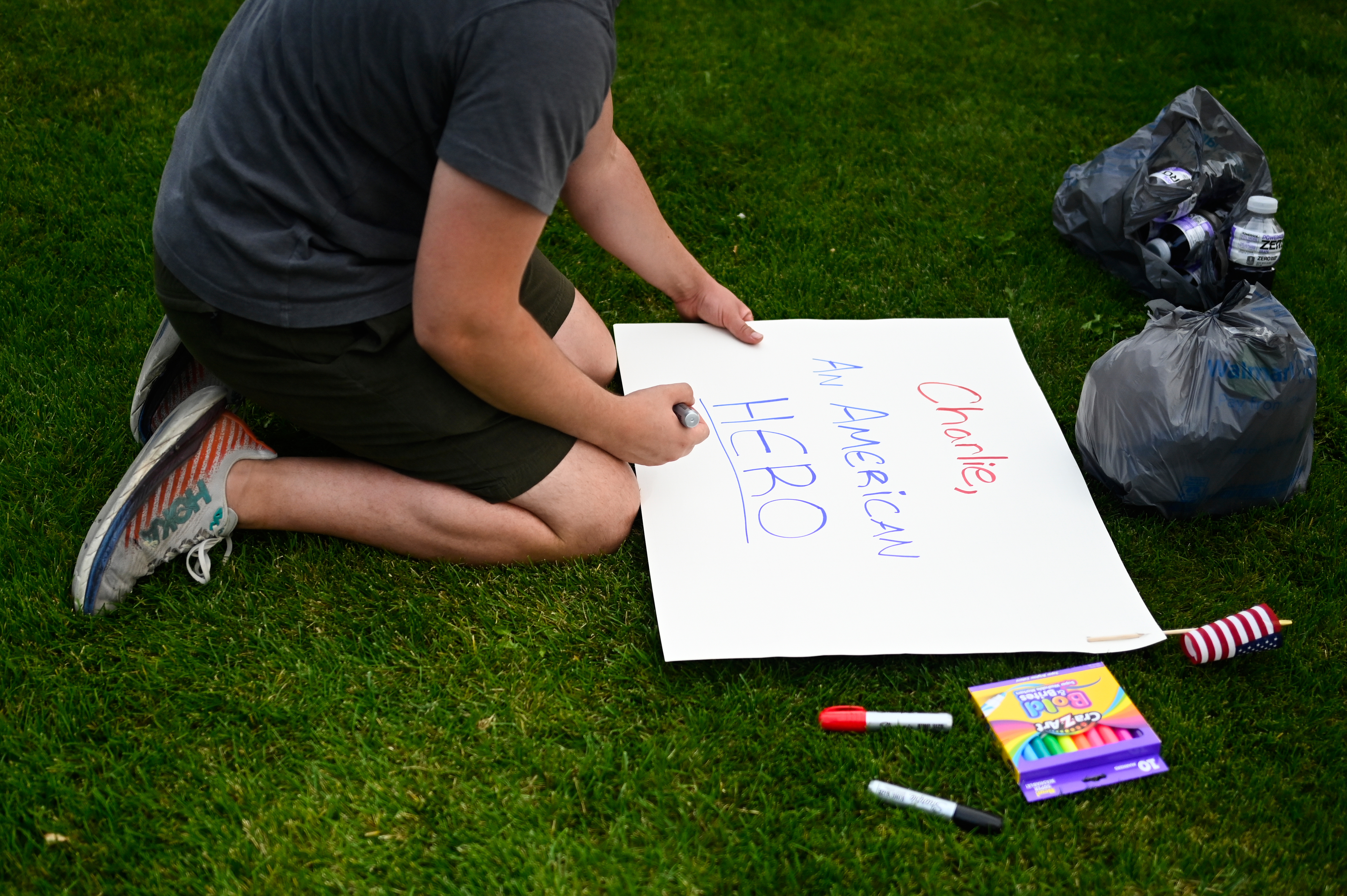 An attendee makes signs at a vigil for Charlie Kirk, the CEO and co-founder of Turning Point USA, who was shot and killed at Utah Valley University earlier in the day, at Timpanogos Regional Hospital, Wednesday, Sept. 10, 2025, in Orem, Utah. (Alex Goodlett - FR171569 AP)