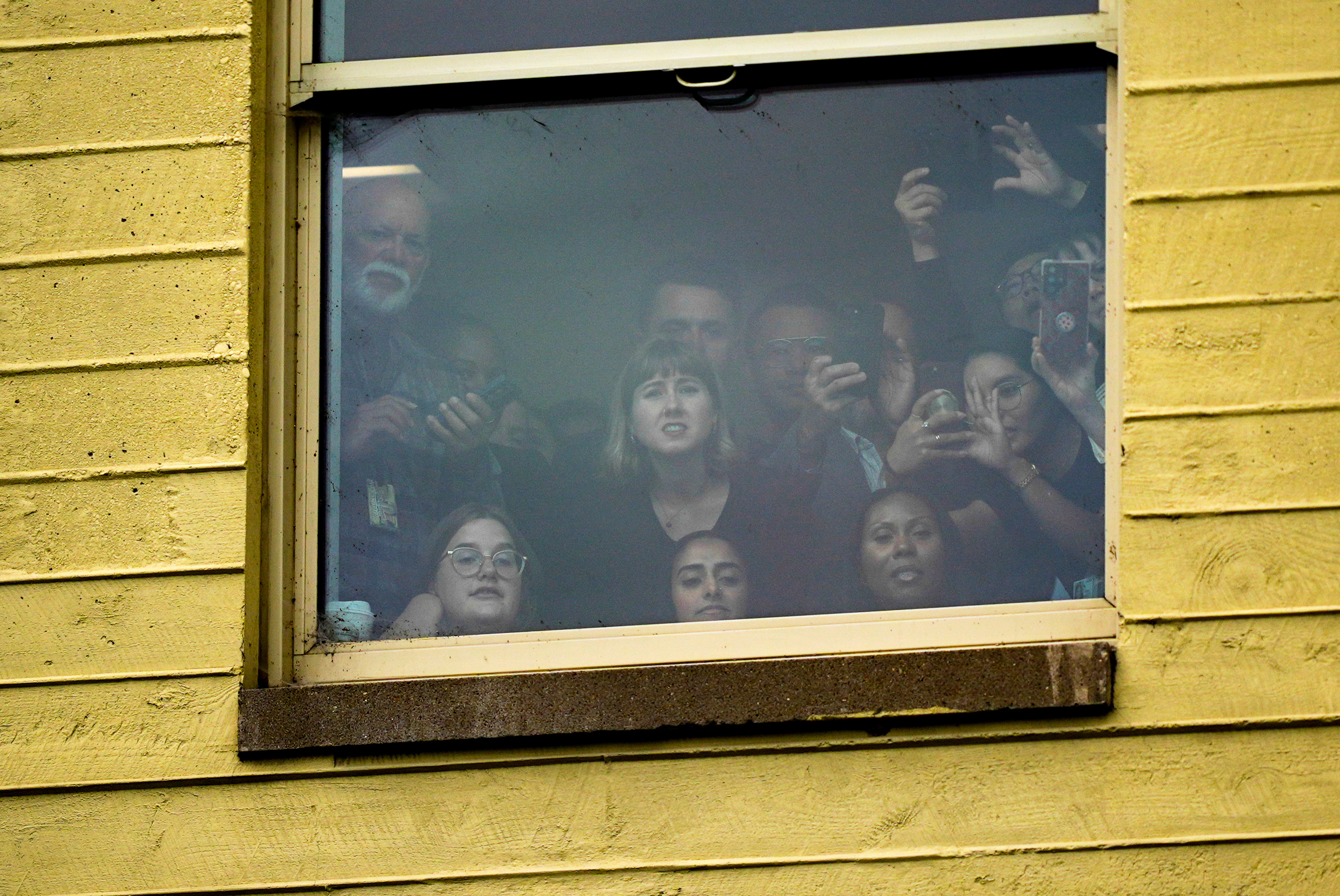 People watch from a window as President Donald Trump attends a ceremony in the Pentagon courtyard to commemorate the 24th anniversary of the 9/11 attacks, Thursday, Sept. 11, 2025, in Washington. (Julia Demaree Nikhinson - AP)