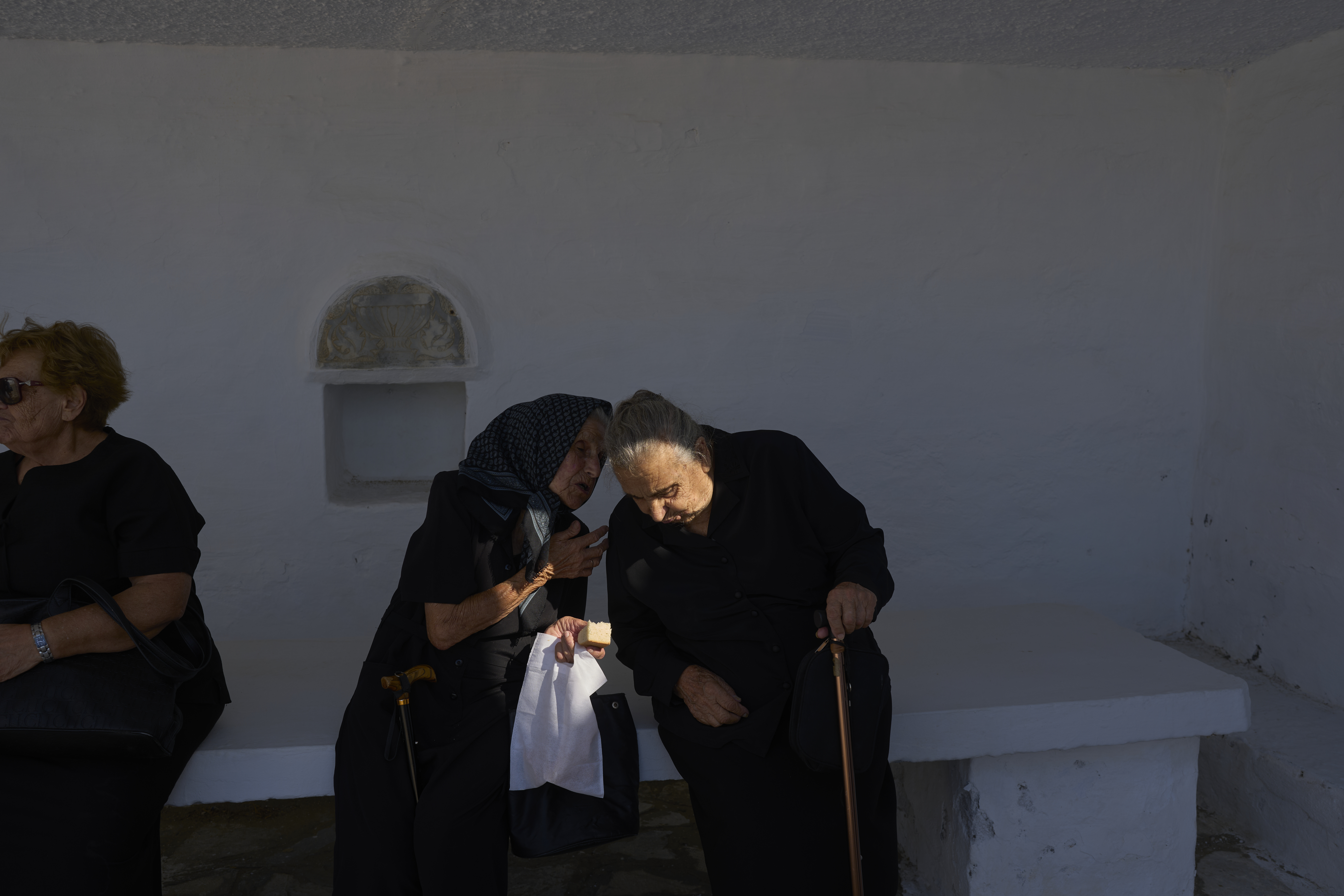 Ioanna Louvari, 96, talks with another elderly woman during a liturgy at the family-owned Agios Sostis chapel on the island of Tinos, Greece, Monday, Sept. 8, 2025. (Petros Giannakouris - AP)
