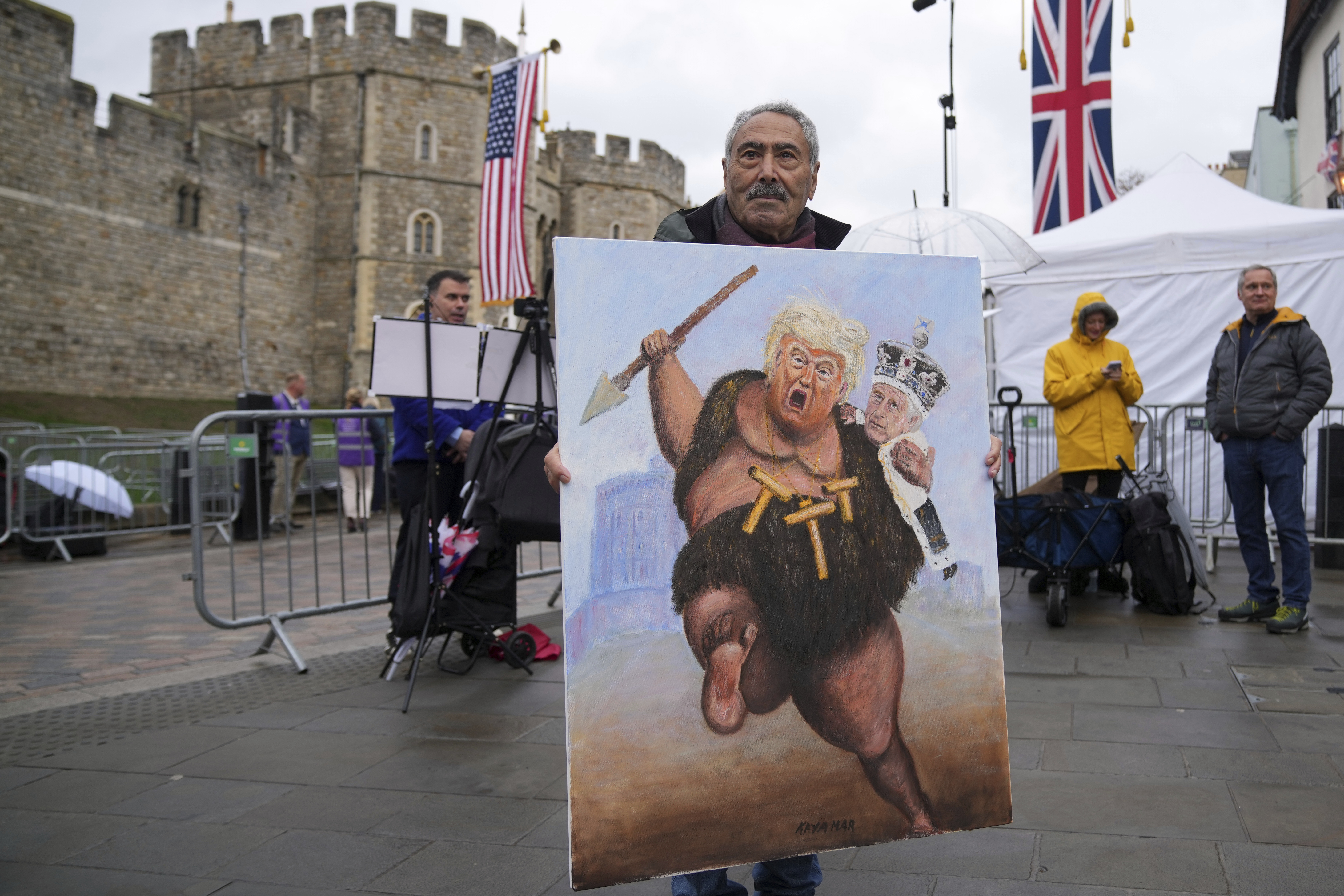 Artist Kaya Mar poses with his latest painting besides Windsor Castle ahead of the arrival of President Donald Trump in Windsor, England, Wednesday, Sept. 17, 2025. (Alastair Grant - AP)