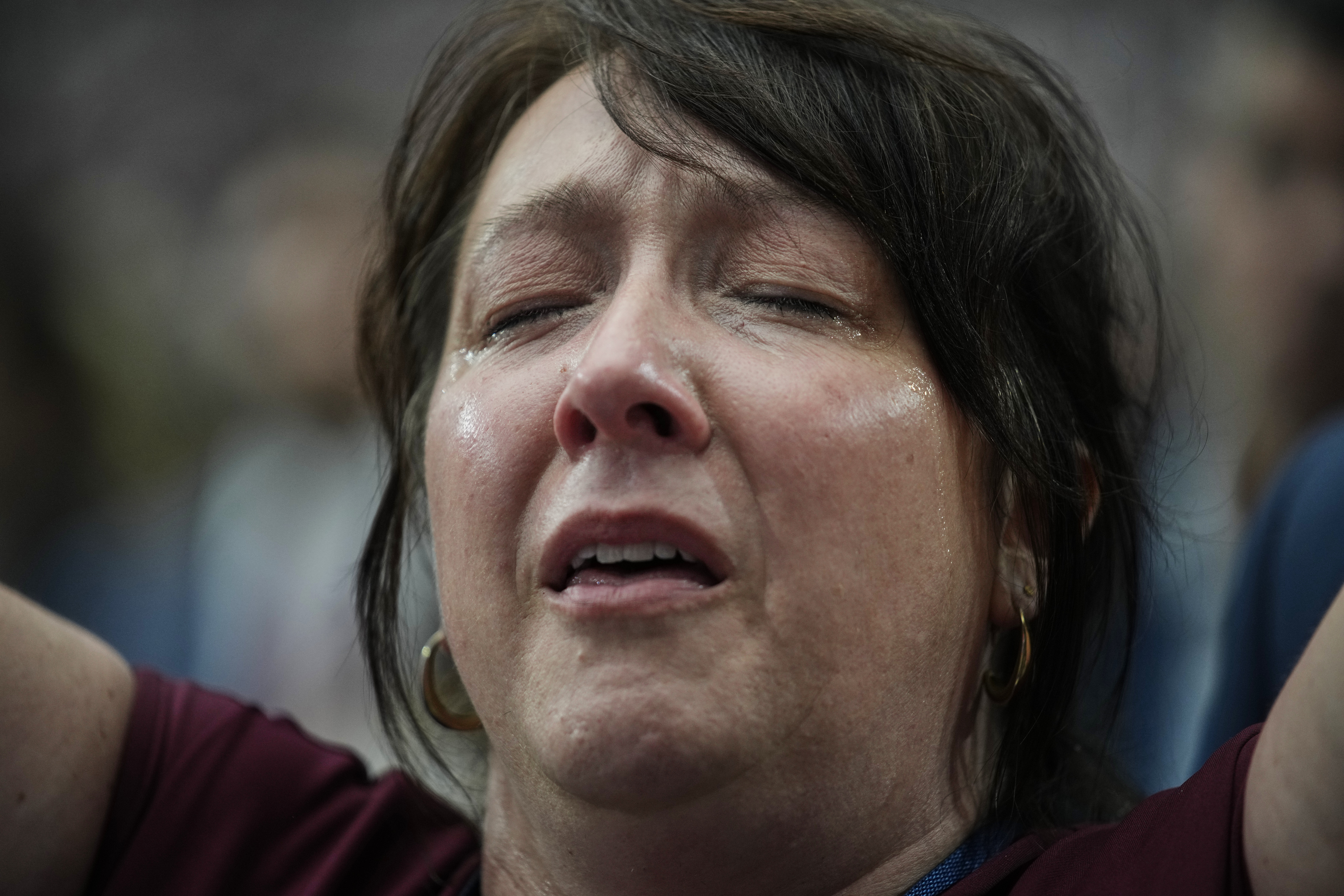 A woman is overcome with emotion while watching a Charlie Kirk tribute video during a memorial for the conservative activist Sunday, Sept. 21, 2025, at State Farm Stadium in Glendale, Ariz. (John Locher - AP)