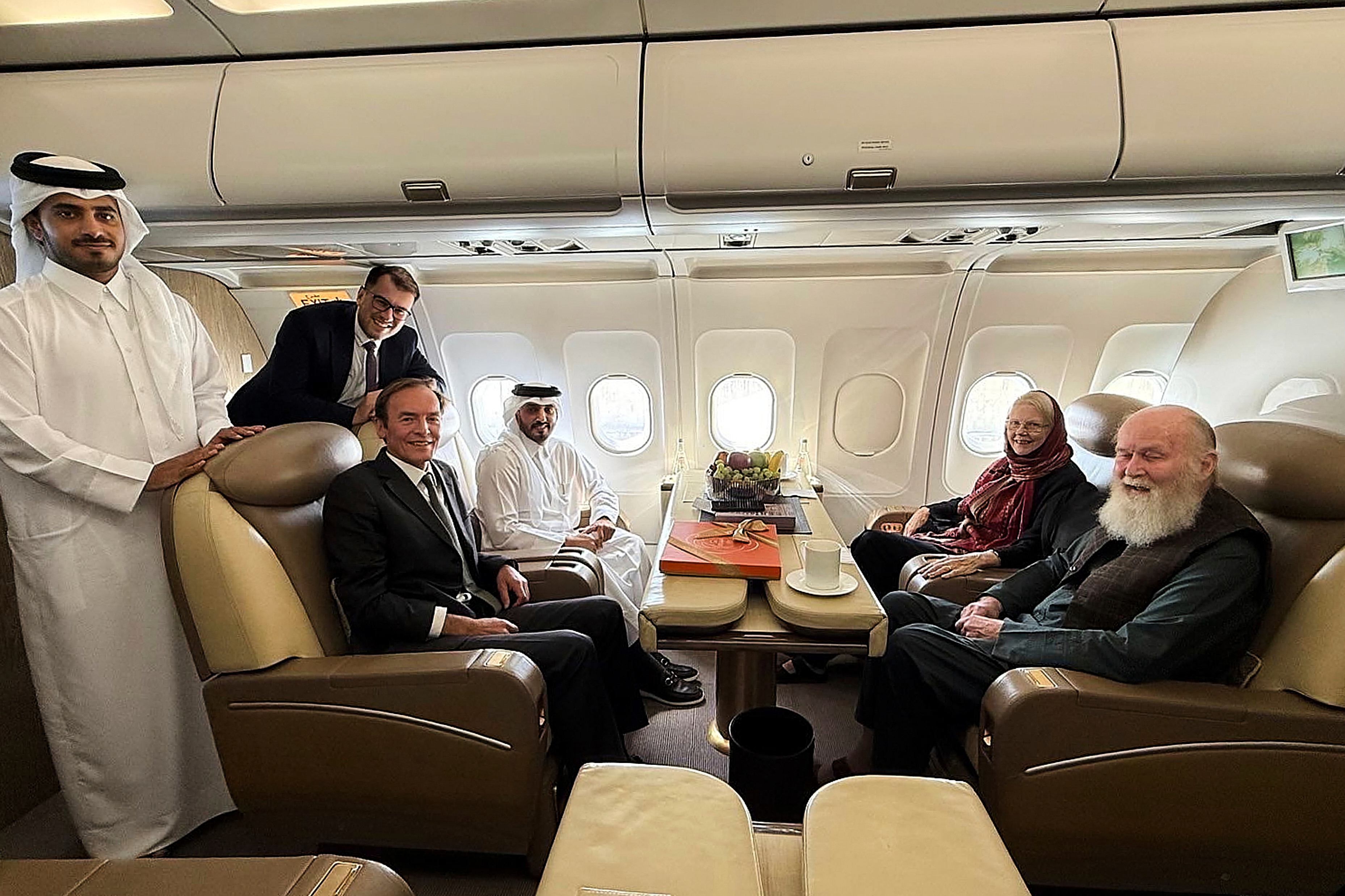 In this photo provided by Qatar Foreign Ministry, Qatari and British diplomats, left, pose with the released British couple, Barbie and Peter Reynolds, aboard a plane before departing to Qatar from Kabul, Afghanistan, Friday, Sept. 19, 2025. (Qatar Foreign Ministry - Qatar Foreign Ministry)