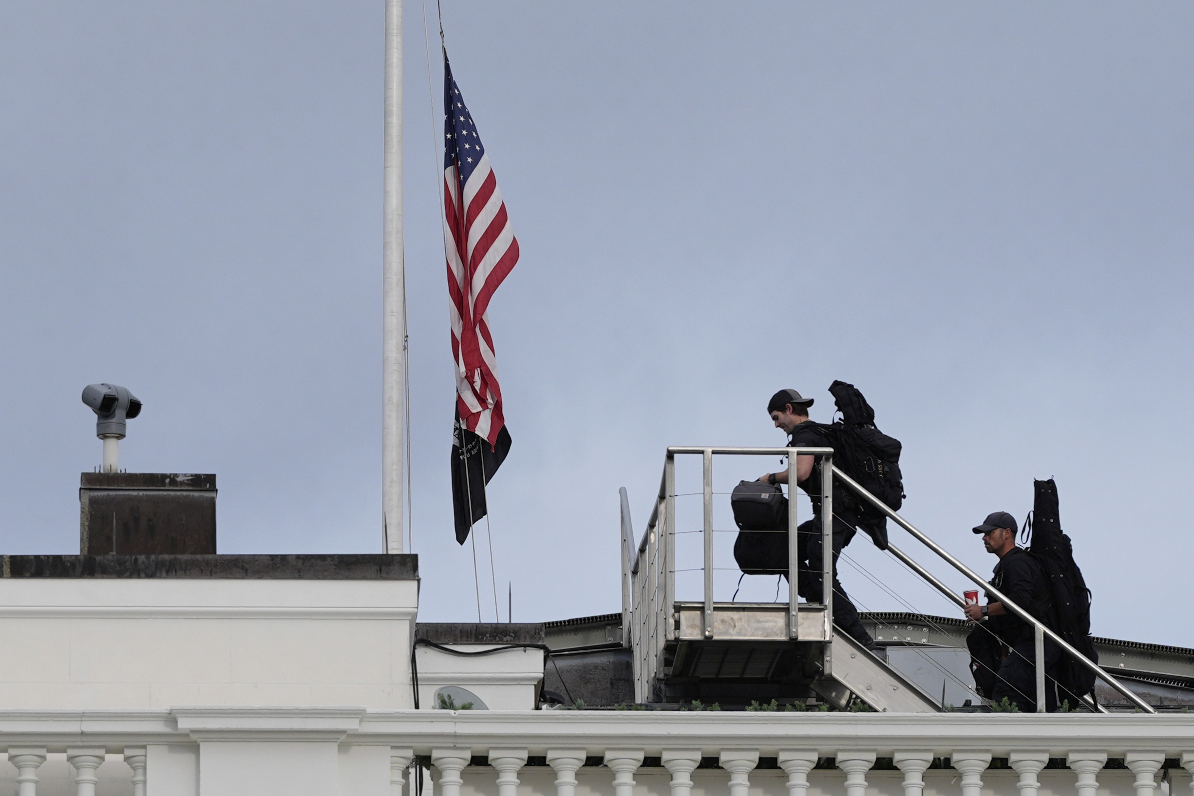Members of the U.S. Secret Service counter sniper team walk onto the roof of the White House after the American flag at the White House in Washington, was lowered to half-staff after Charlie Kirk, the CEO and co-founder of Turning Point USA, was killed at an event in Orem, Utah, Wednesday, Sept. 10, 2025. (Alex Brandon - AP)