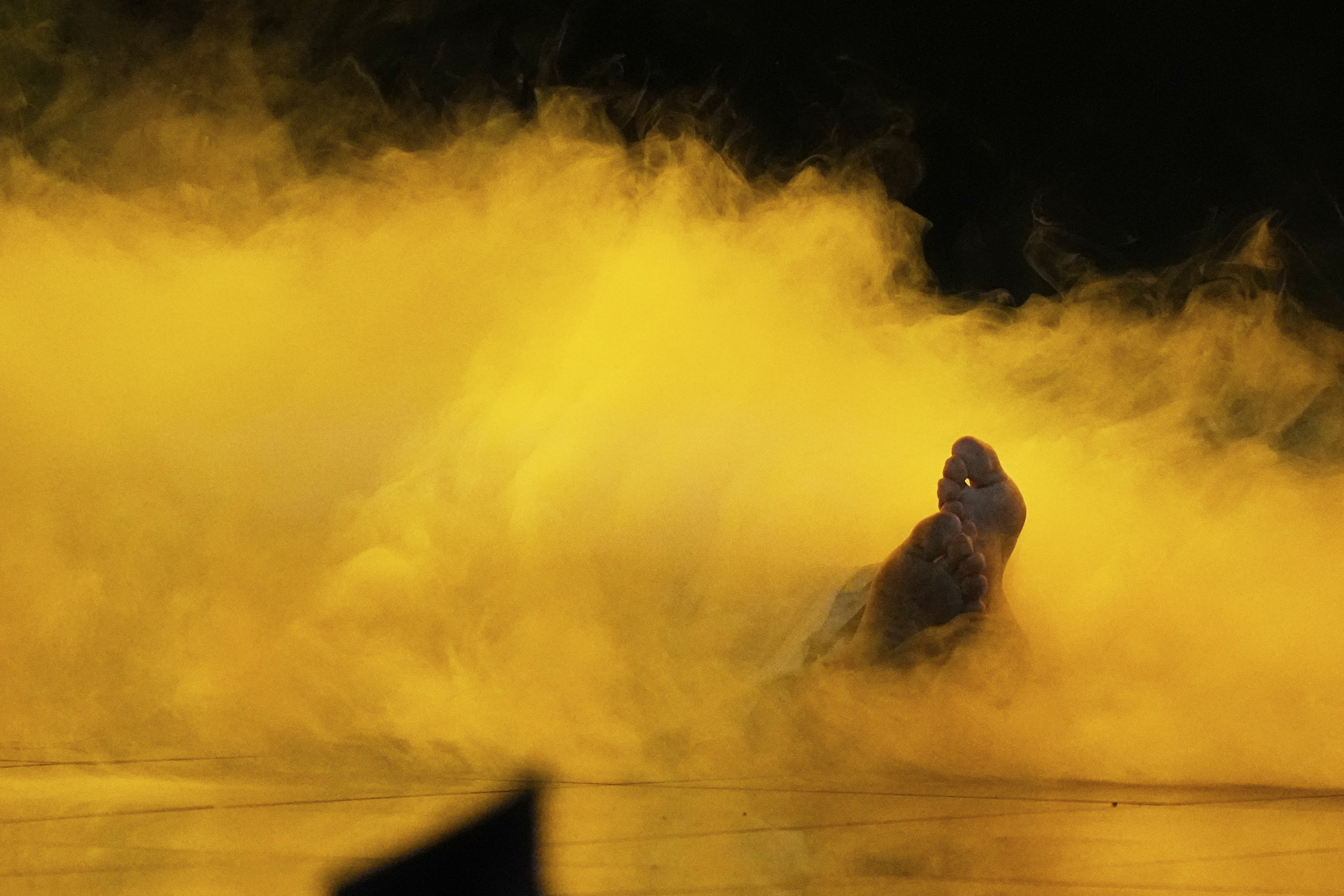 Kazakhstan's Yernar Sadirbayev (Amre) lies in a cloud of smoke as he performs the song 