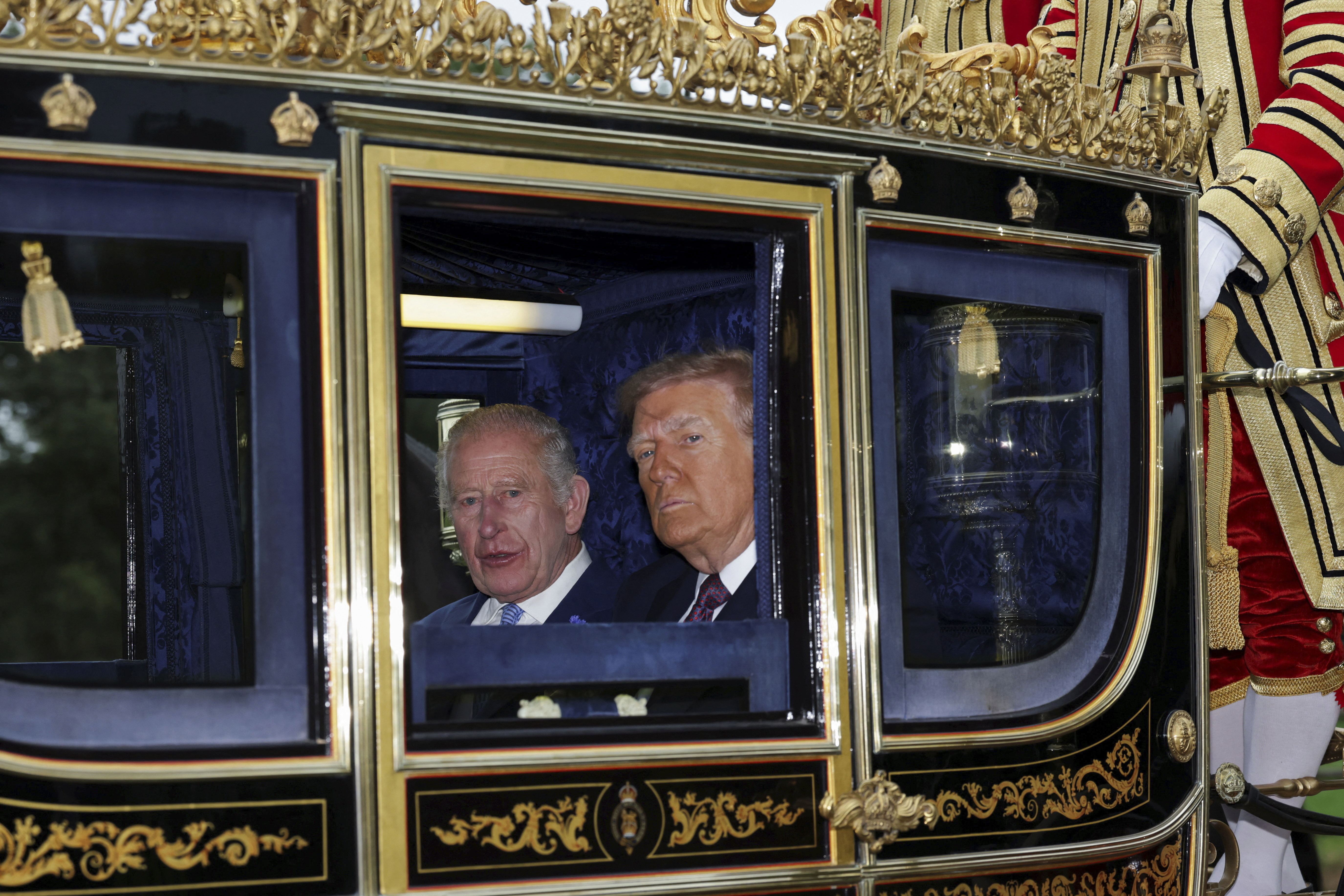 Britain's King Charles III and President Donald Trump sit in a carriage during a procession through Windsor Castle, in Windsor, England, Wednesday, Sept. 17, 2025. (Toby Melville - Pool Reuters)