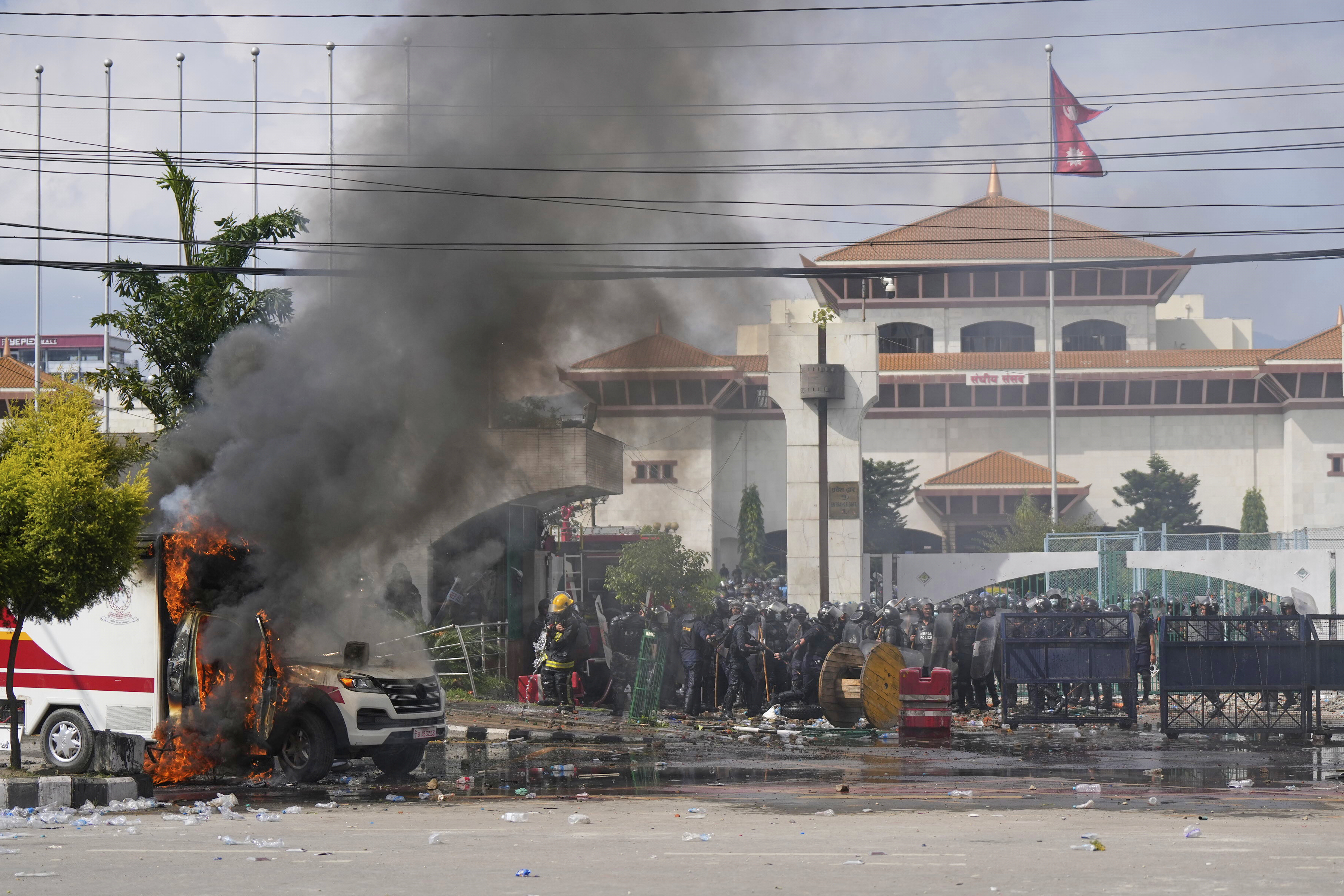 Riot police guard parliament building while an ambulance burns during protests in Kathmandu, Nepal, Monday, Sept. 8, 2025. (Niranjan Shrestha - AP)