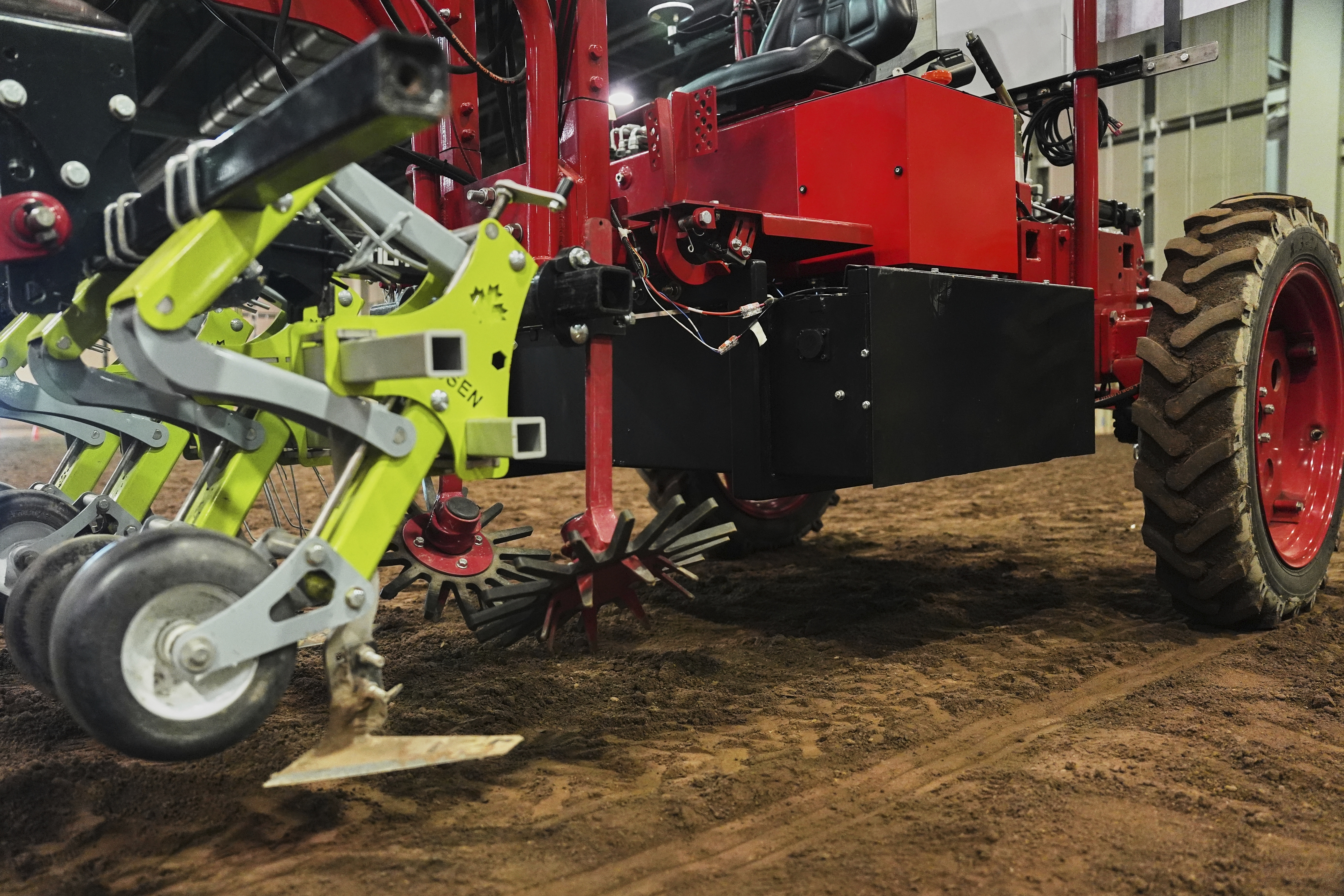 Farm implements, at left, and a battery, are attached to the underside of an electric tractor Tuesday, Aug. 19, 2025, in East Lansing, Mich. (Joshua A. Bickel - AP)