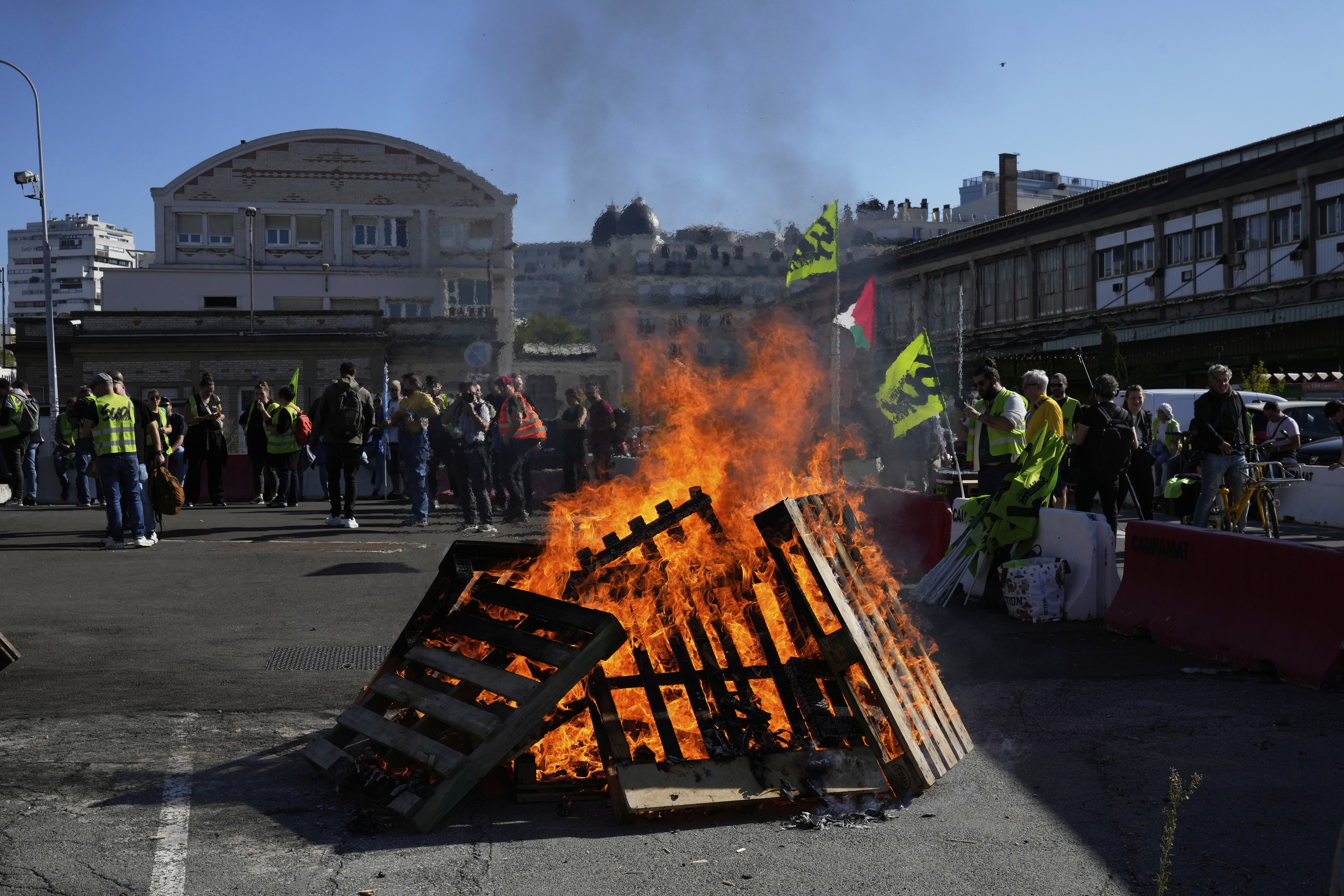 Workers gather next wooden pallets on fire at the Gare de Lyon train station during a protest called by major trade unions to oppose budget cuts, in Paris, France, Thursday, Sept. 18, 2025. (Michel Euler - AP)