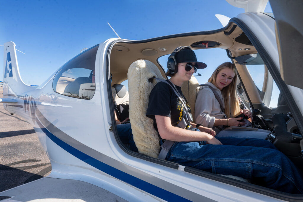 Two young ladies sit in an airplane.