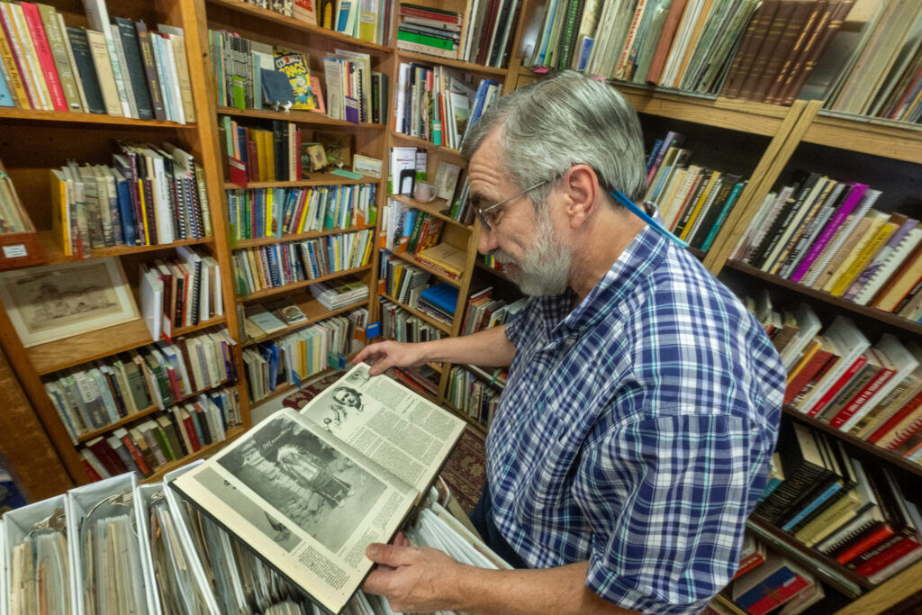 In the “El Paso County Colorado Heritage” book, Bob DeWitt opens to a page showing Chief Manitou at his “Secret Bookshop” in Fountain on Tuesday, Oct. 7, 2025. (The Gazette, Jerilee Bennett)
