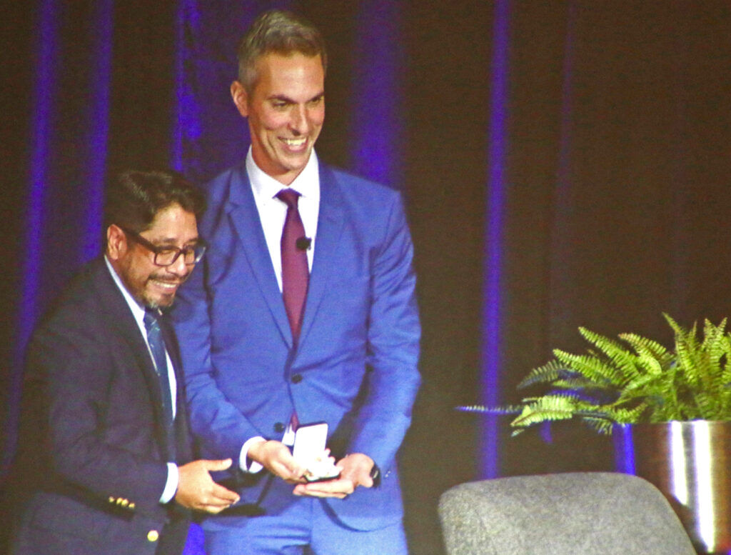 Nathan Fernando-Frescas, left, a host for 'All Things Considered' on CPR News and a Denver Press Club board member, presents the Damon Runyon Award to former colleague Ari Shapiro on Oct. 18, 2025, at the Hyatt Regency downtown. DENVER GAZETTE PHOTO