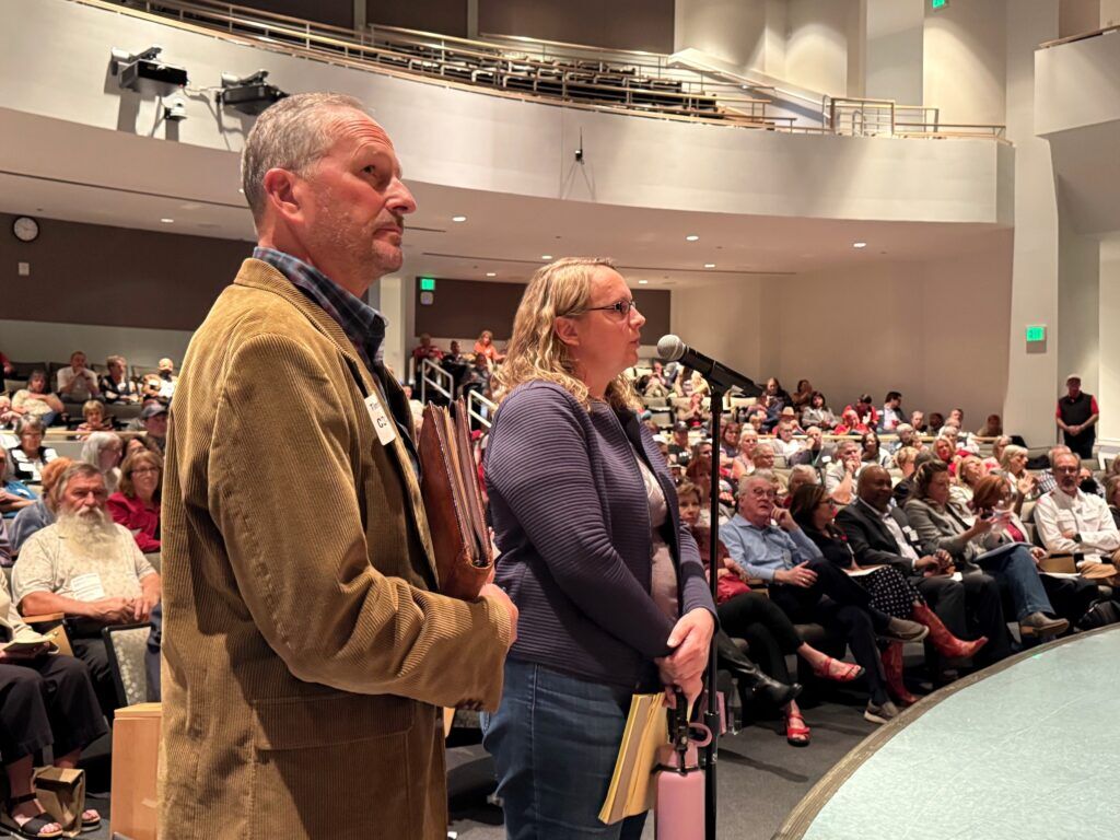 State Rep. Stephanie Luck, R-Fremont County, and former state Rep. Tim Leonard, R-Evergreen, await a turn to speak at the microphone during a meeting of the Colorado Republican Party's state central committee on Saturday, Sept. 27, 2025, in Aurora. (Ernest Luning/Colorado Politics)