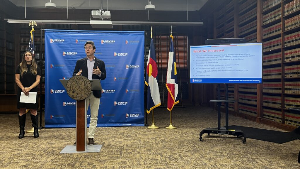 a city official standing at a podium in a conference room.