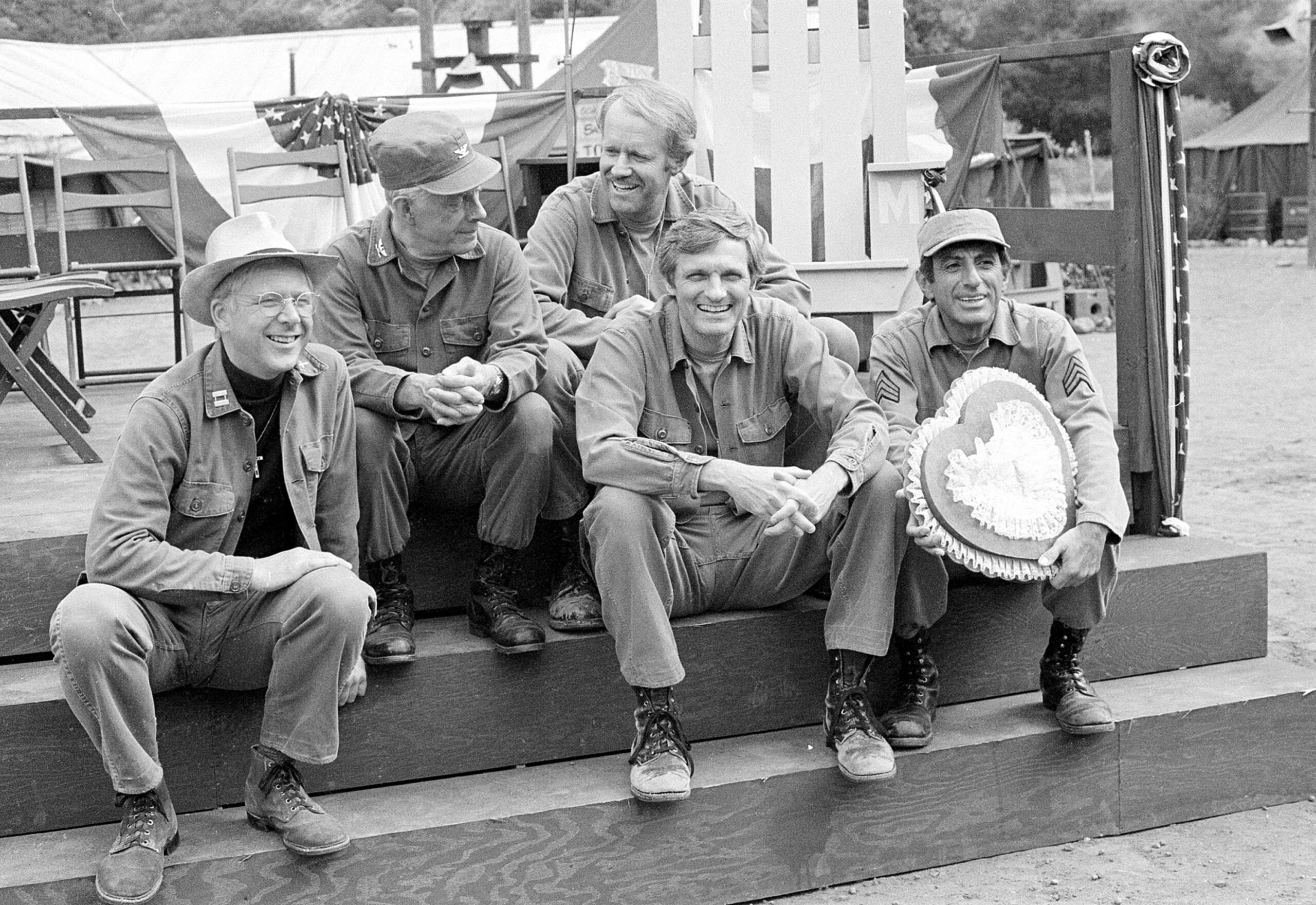 Cast members of the television series 'M*A*S*H' from left, William Christopher, Harry Morgan, Mike Farrell, Alan Alda and Jamie Farr, take a break on the set during taping in Los Angeles. This was from 1982. WALLY FONG/ASSOCIATED PRESS