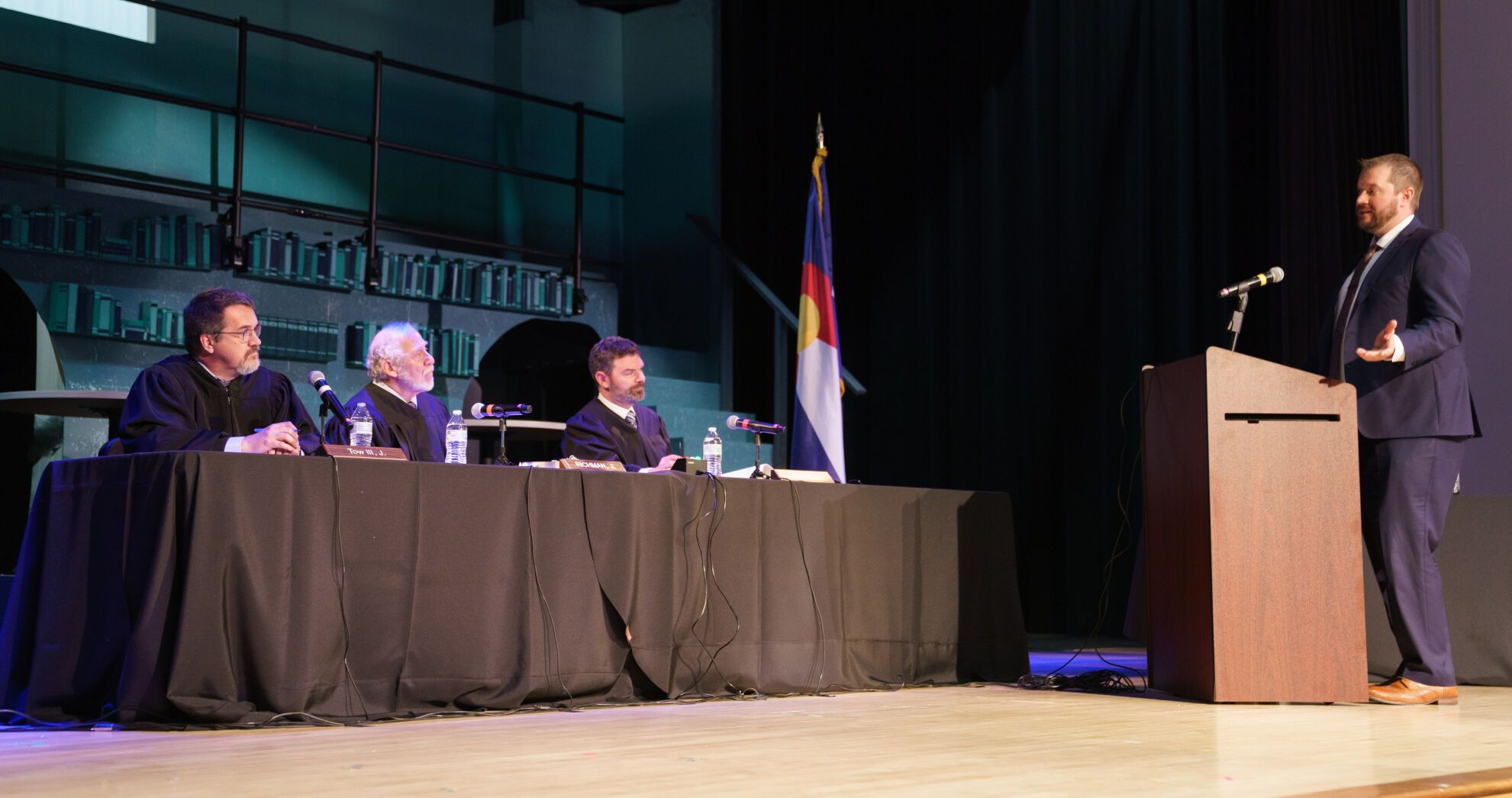 Judges Ted Tow III, David Richman, and Matthew Grove hear oral arguments by Winslow Taylor III, right. STRIVE Prep-RISE high school hosts a Courts in the Community event, featuring oral arguments before a three-judge panel with the Colorado Court of Appeals, at STRIVE Prep–Green Valley Ranch in Denver on April 19, 2022.