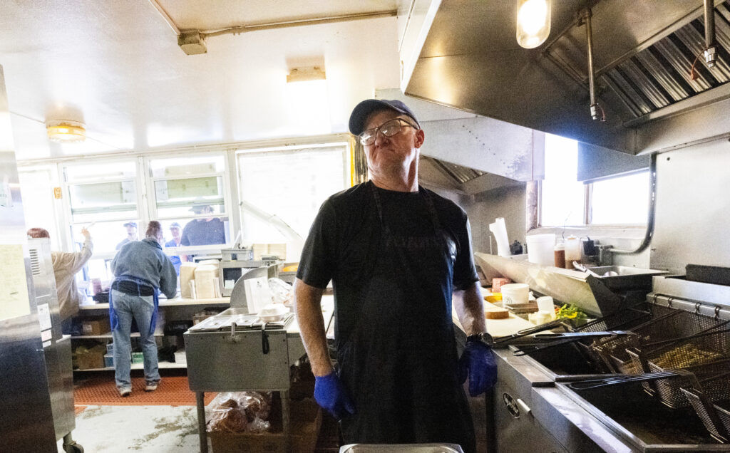 Jay Miller, brother of Big Burger World owner Regina Misurelli, cracks a joke while working the fryer at the Canon City restaurant on Wednesday, Oct. 29, 2025. Miller helps out at the family restaurant when he isn't skiing or playing in the mountains. (The Gazette, Christian Murdock)
