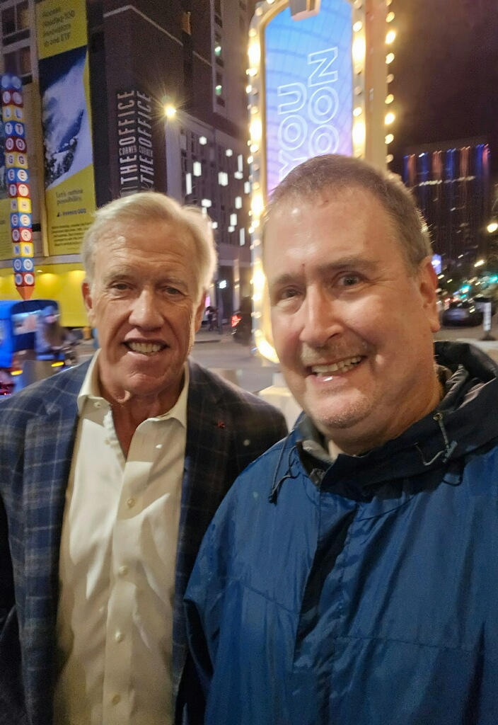 Ron Katz, the Denver Broncos' official 2021 Fan of the Year, ran into John Elway outside of the Ellie Caulkins Opera House on Nov. 8, 2025, and the NFL great agreed to a photograph. (Provided by Ron Katz)