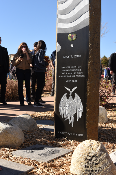 A stone memorial with a crowd of people around it