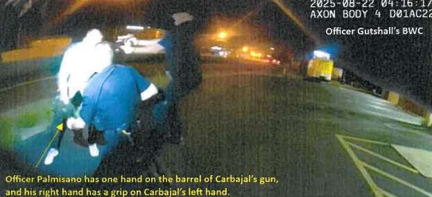 A screenshot from a camera recording of police confronting a man holding an apparent gun