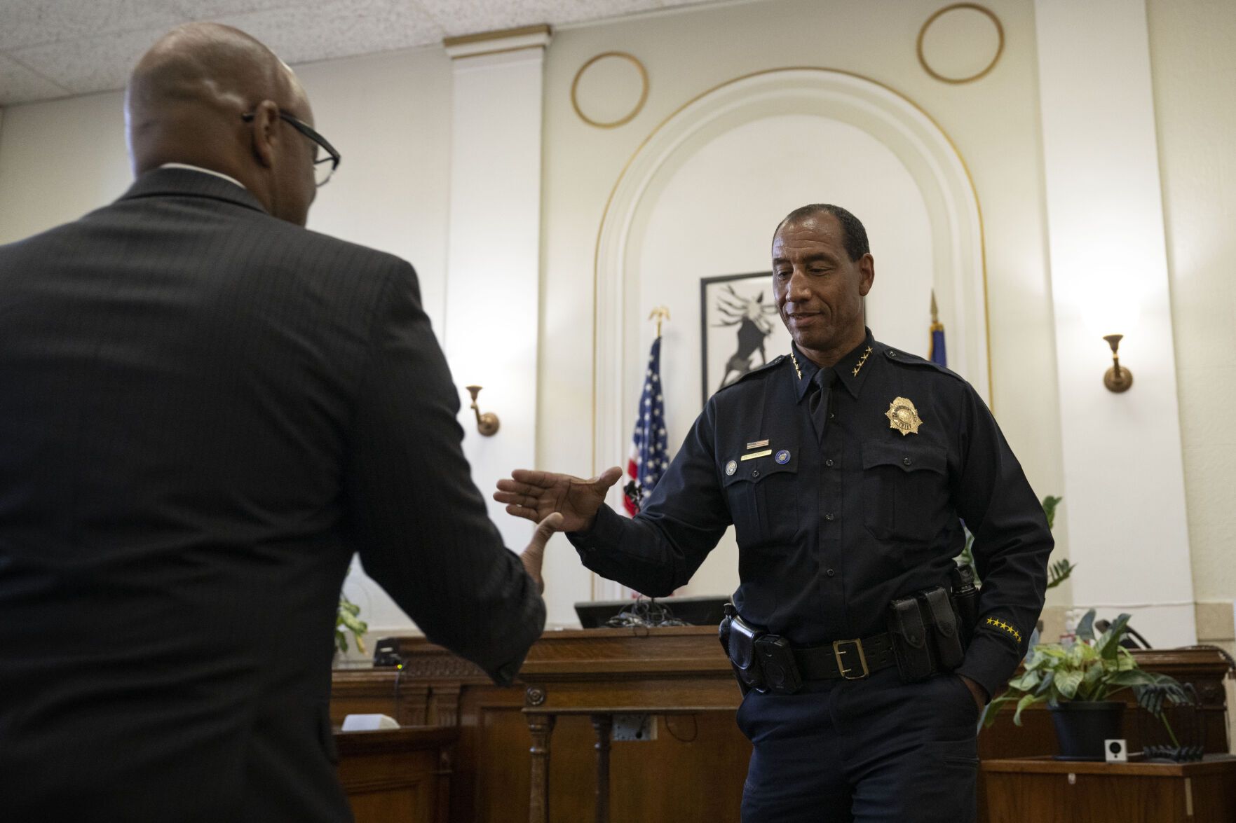 a police officer shakes the hand of a man in a suit