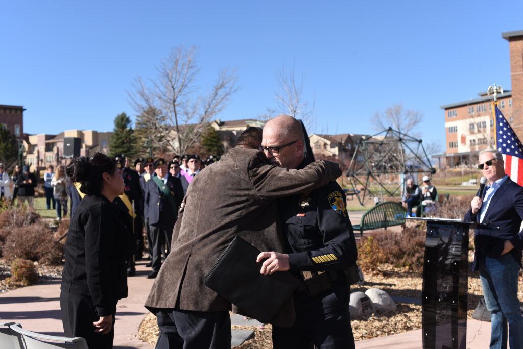 Two people hugging each other under a blue sky