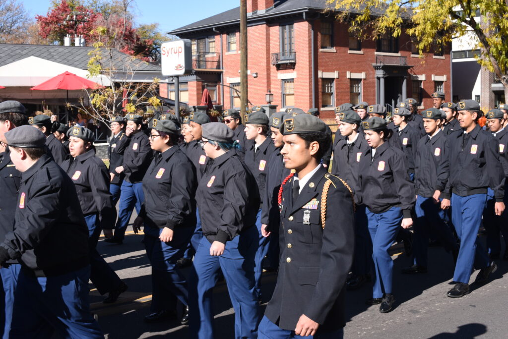 A group of people dressed as military members walking down a road