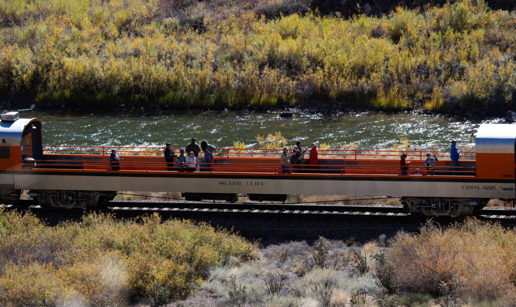 Passengers on the Royal Gorge Route Railroad take in the view of the Arkansas River and the Gorge above Wednesday, Oct. 29, 2025, as the train travel below the Tunnel Drive Trail west of Canon City. (The Gazette, Christian Murdock)
