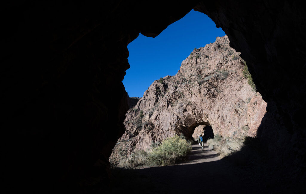 A hiker walks between tunnels at the beginning of the Tunnel Drive Trail along the Arkansas River west of Canon City Wednesday, Oct. 29, 2025. The 1.92-mile trail connect to the Royal Cascade Trail that climbs 1,800-feet over 3.6 miles to the top of the gorge. (The Gazette, Christian Murdock)