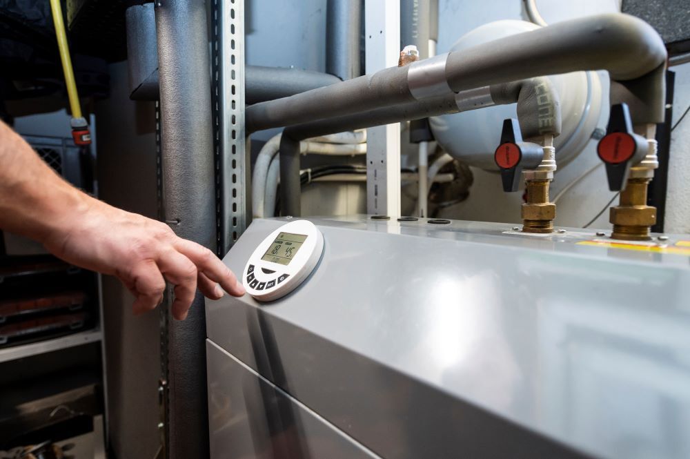 A man operates an air-source heat pump located in the basement of a residential building. The heat pump is considered the environmentally friendly and future-proof alternative to oil and gas heating. (Gazette file)