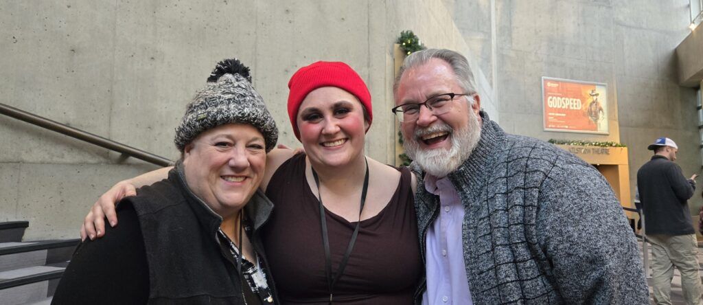 Olivia Wilson, center, is greeted by her parents after making her debut as a replacement actor in the Denver Center Theatre Company's 'A Christmas Carol' on Nov. 23, 2025. She’s with mom, Leslie O'Carroll, left, and dad Steve Wilson. O'Carroll had just simultaneously performed nearby in 'Dracula: A Comedy of Terrors." (Courtesy Olivia Wilson) 