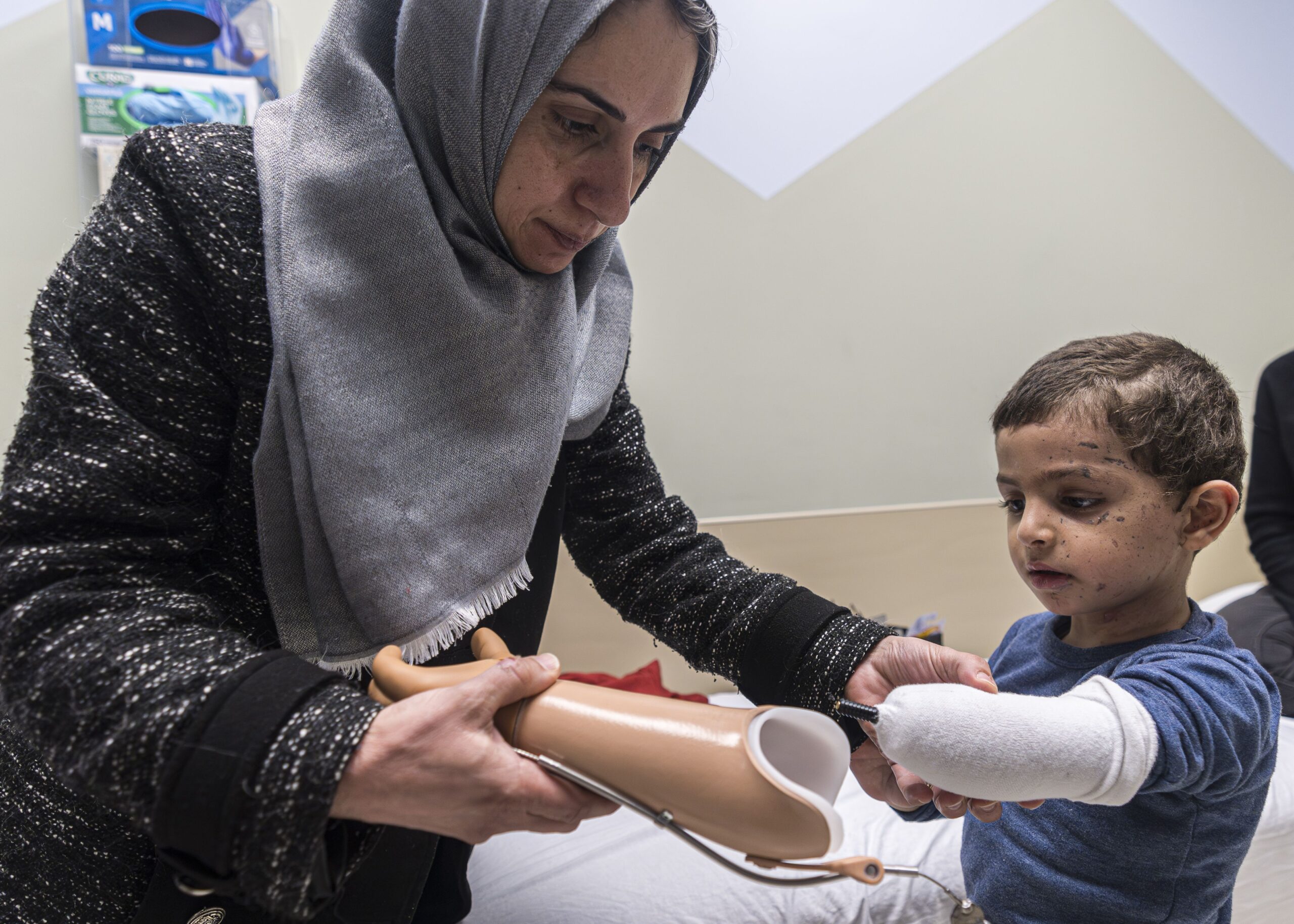 Maha Abu Kuwaik helps her nephew, 4-year-old Omar Abu Kuwaik, attach his new prosthetic arm at Shriners Children's Hospital on Wednesday, Feb. 28, 2024, in Philadelphia. Through the efforts of family and strangers, Omar was brought out of Gaza and to the United States, where he received treatment, including a prosthetic arm. He spent his days in a house run by a medical charity in New York City, accompanied by his aunt. (Gazette file)
