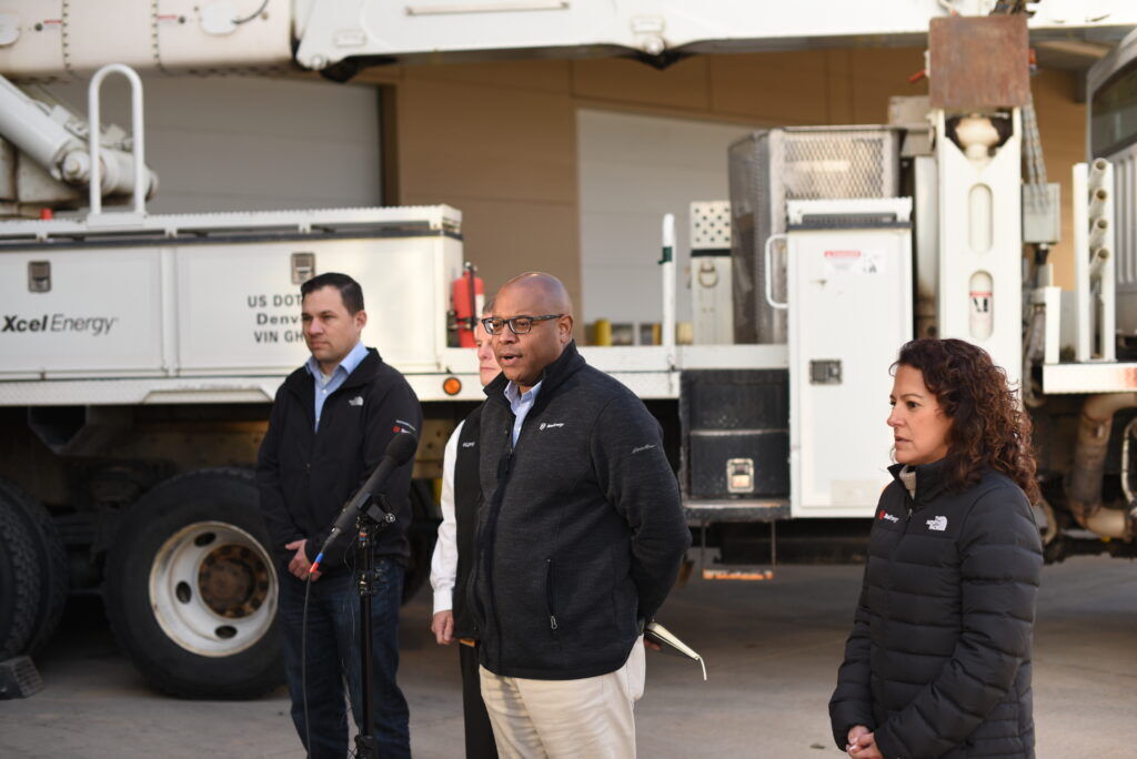 A standing man speaks at a microphone