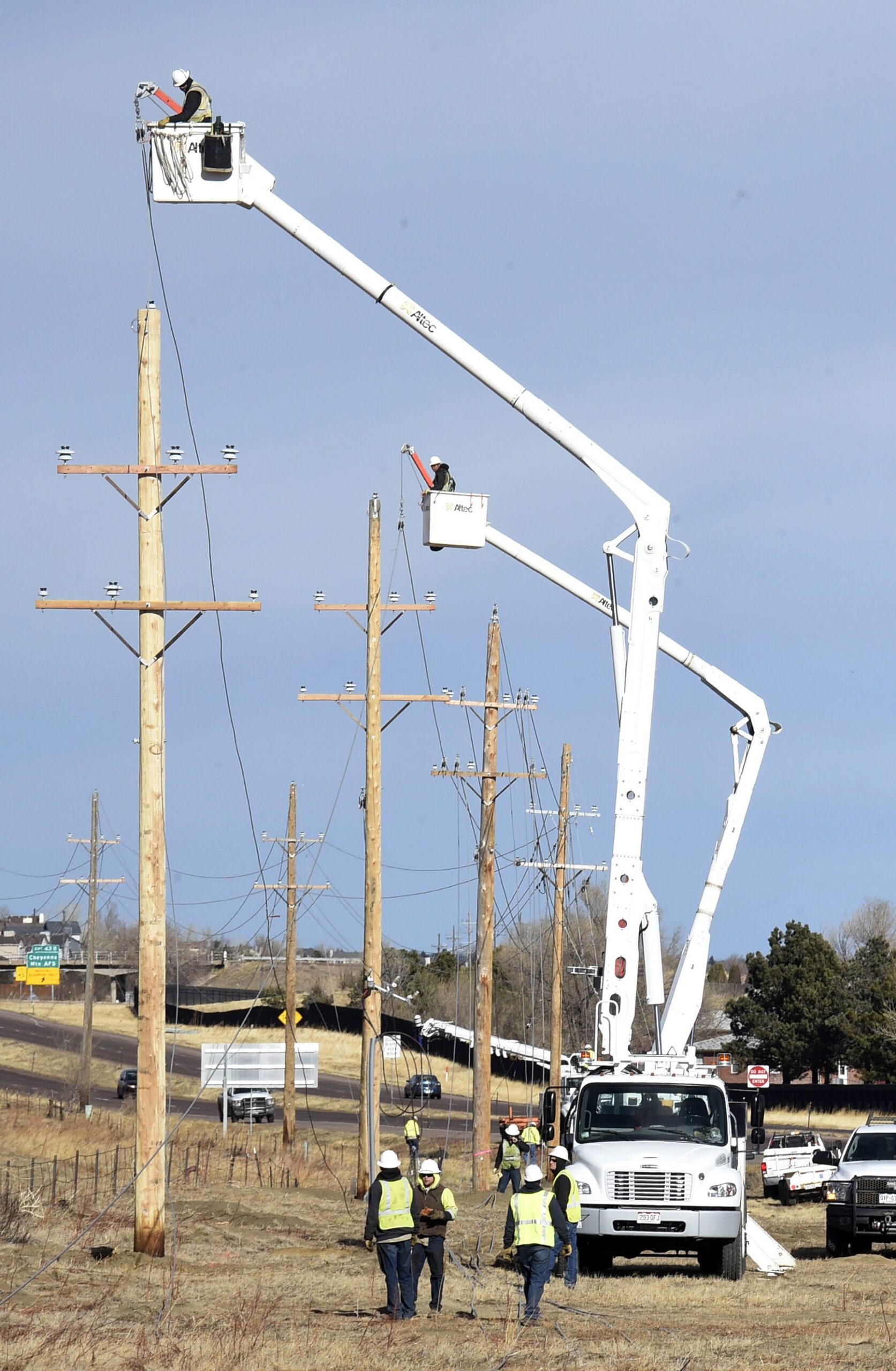 powerline manlift trucks and workers repairing downed power lines