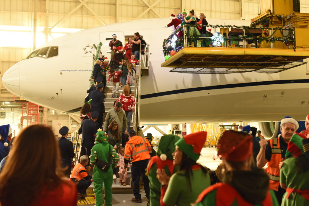People deboard a plane inside a hanger