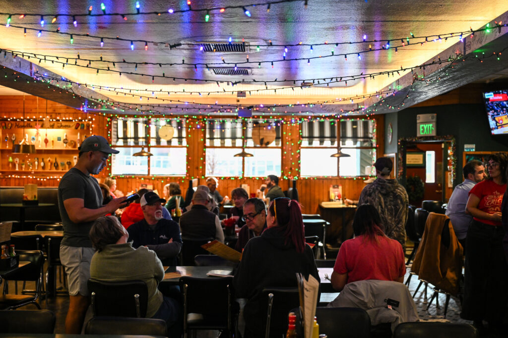 People get lunch beneath the hockey rink on the ceiling at the Cherry Cricket in Cherry Creek on Friday, Dec. 12, 2025.