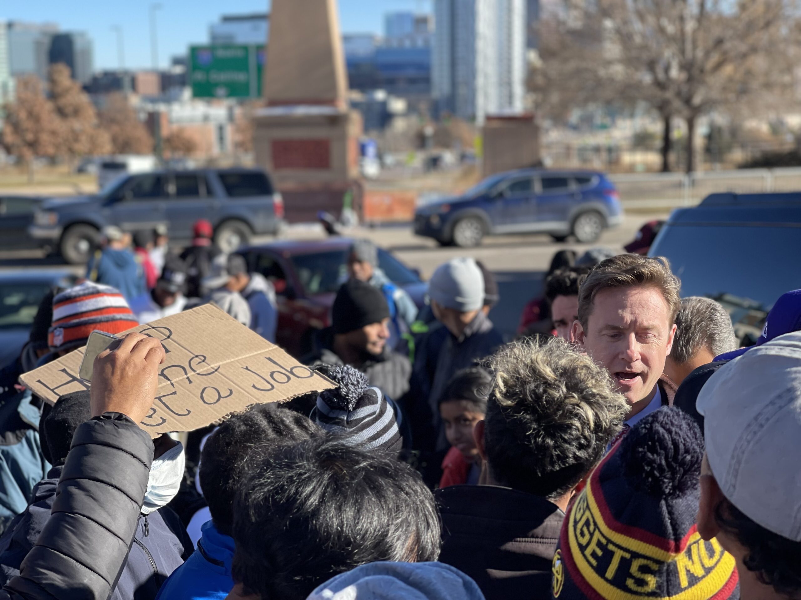 FILE PHOTO: Paying a visit to a large encampment on Zuni Street, Mayor Mike Johnston is surrounded by immigrants wanting to talk to him on Dec. 29, 2024, days before the city removed roughly 200 tents and relocated campers. (Nicole C. Brambila
nico.brambila@denvergazette.com)