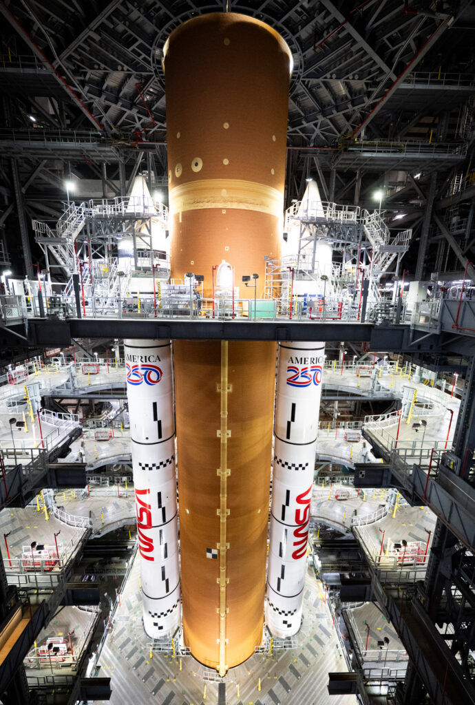 A rocket stands inside an assembly building ahead of traveling to the launch pad. 