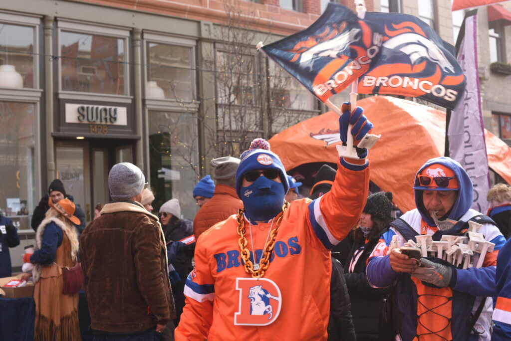 A man in an orange jersey and a big chain