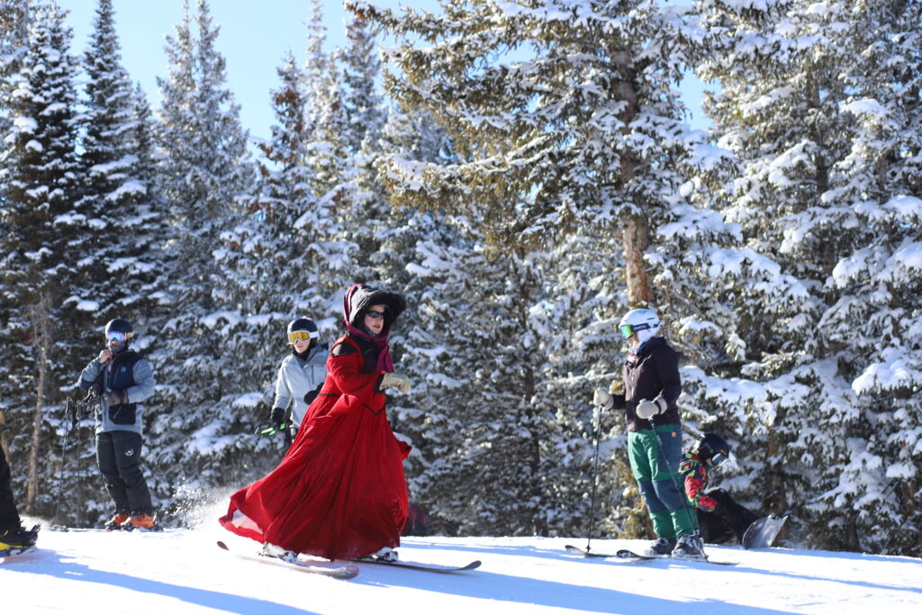 A woman in a red dress skis at Mary Jane.