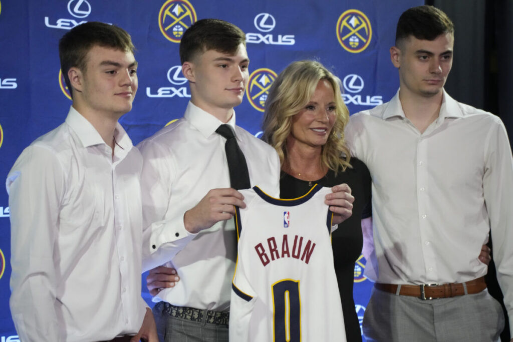 File photo: Denver Nuggets guard Christian Braun, second from left, holds up his jersey for a photo with his brothers Parker, left, and Landon, right, and mother, Lisa, after being introduced to the media during a news conference on June 27, 2022, in Denver. (Courtesy KU Sports.com)