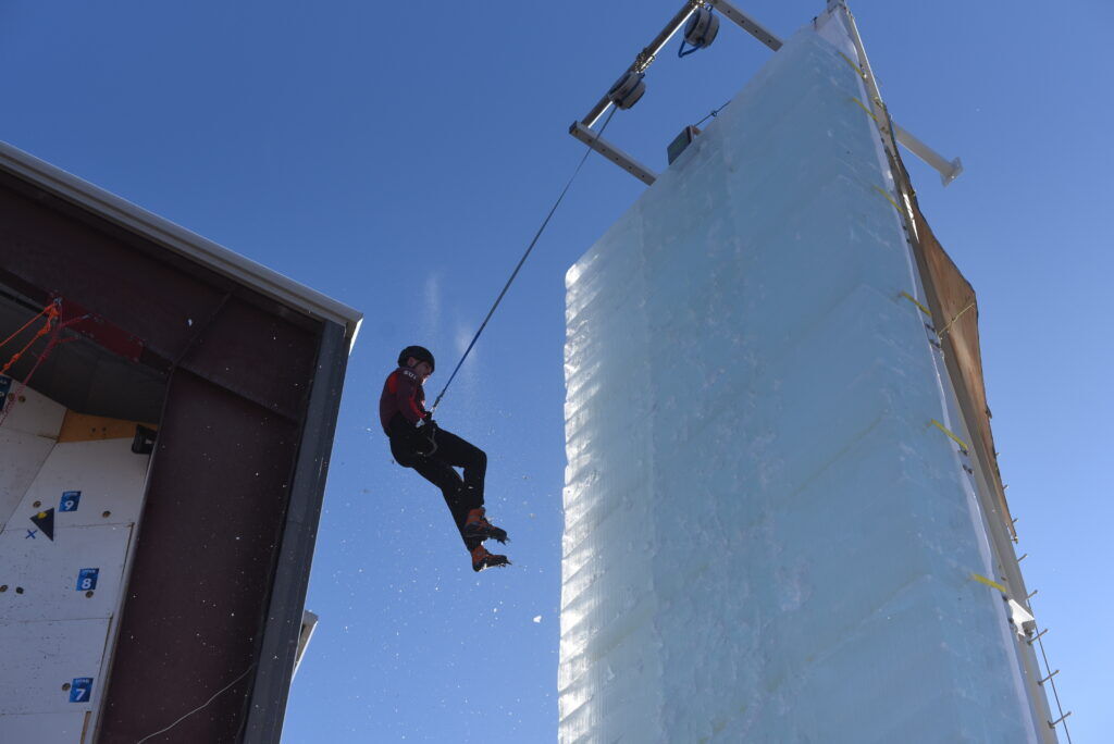 A man gets lowered by a rope down a wall