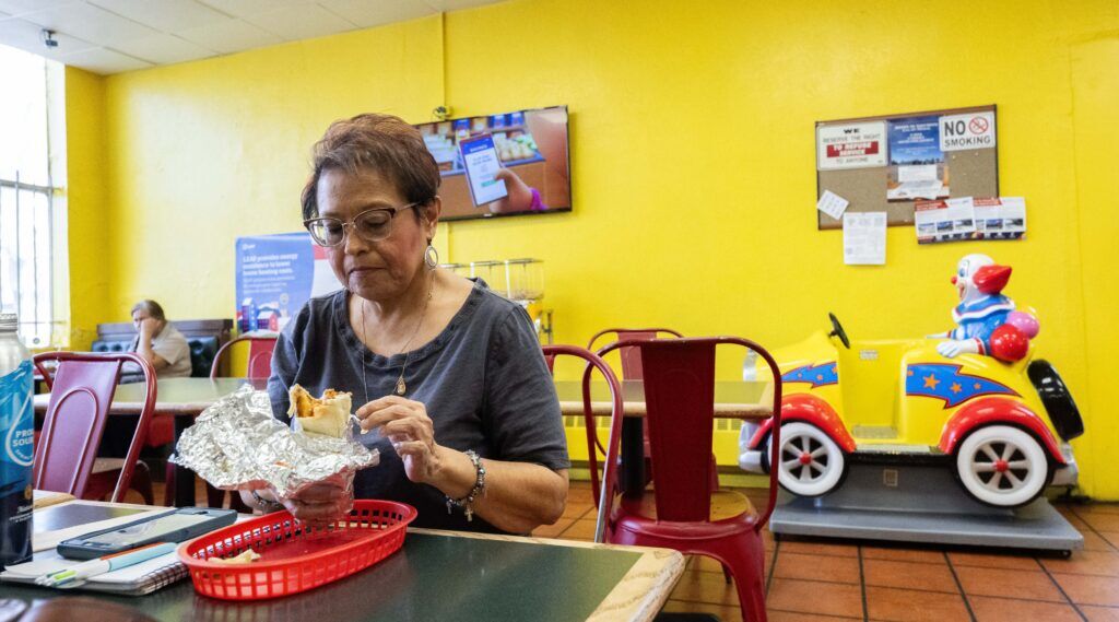 Angela Garcia eats a burrito at Panadería Emmanuel in Globeville on Tuesday, Feb. 24, 2026. The Mexican bakery is a gathering place for people in the neighborhood. (The Gazette, Christian Murdock)