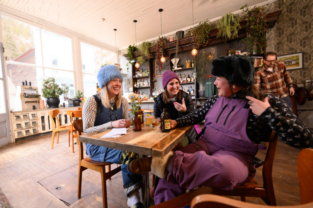 After a day skiing at nearby Loveland Ski Area, Jenny Homan, left,  Allison Beggs, middle, and Ali Jones of Lakewood stopped for drinks at Bread Bar in Silver Plume, Colorado Friday, January 30, 2026. Bread is a small cocktail bar in a former 1800’s bakery in the historic mountain town west of Denver on I-70.  Photo by Mark Reis
