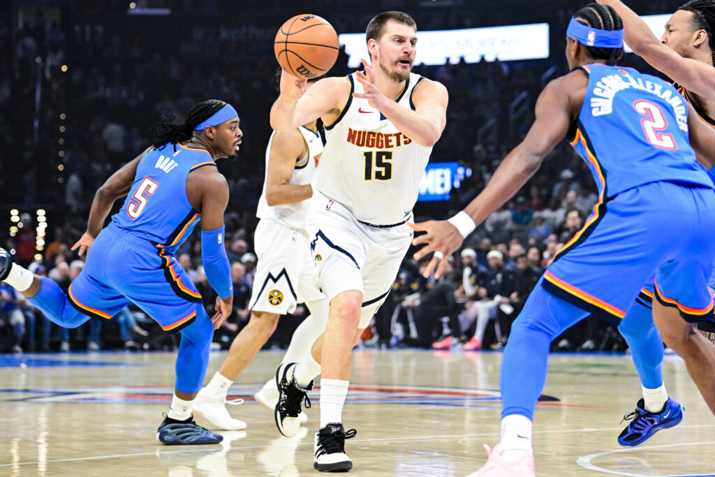 Denver Nuggets center Nikola Jokić (15) passes the ball during the first half of an NBA basketball game against the Oklahoma City Thunder, Monday