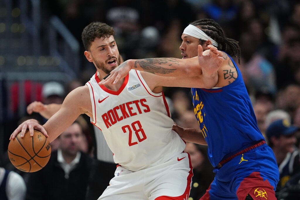 Houston Rockets center Alperen Sengun, left, looks to pass the ball as Denver Nuggets forward Aaron Gordon defends in the first half of an NBA basketball game Wednesday, March 11, 2026, in Denver.