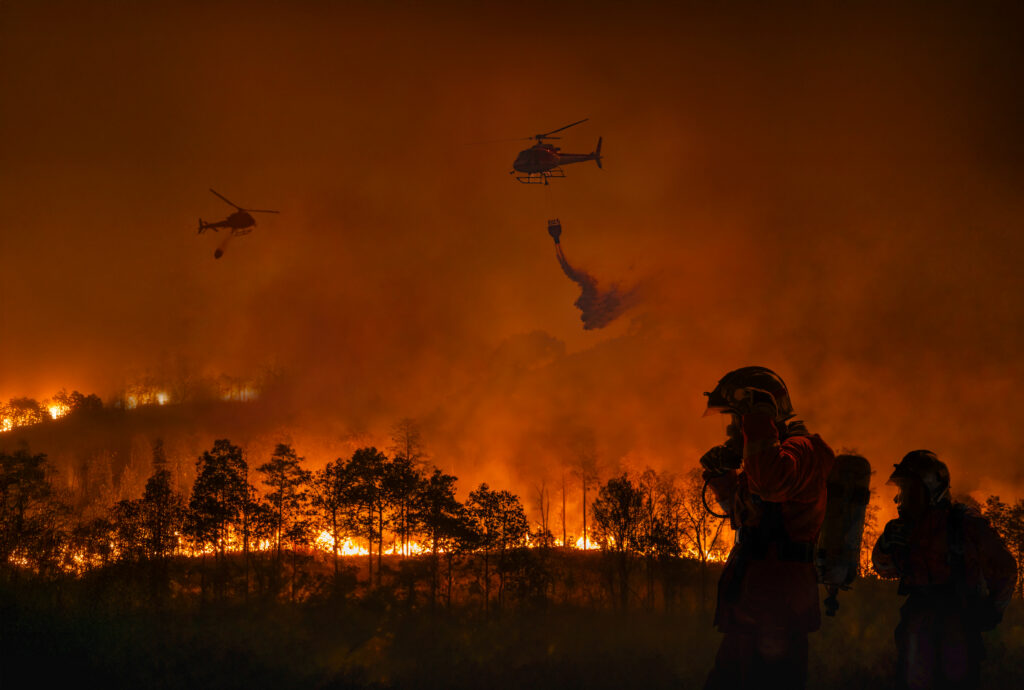 Fire fighting helicopter carry water bucket to extinguish the forest fire. (Courtesy of Toa55, GettyImages).